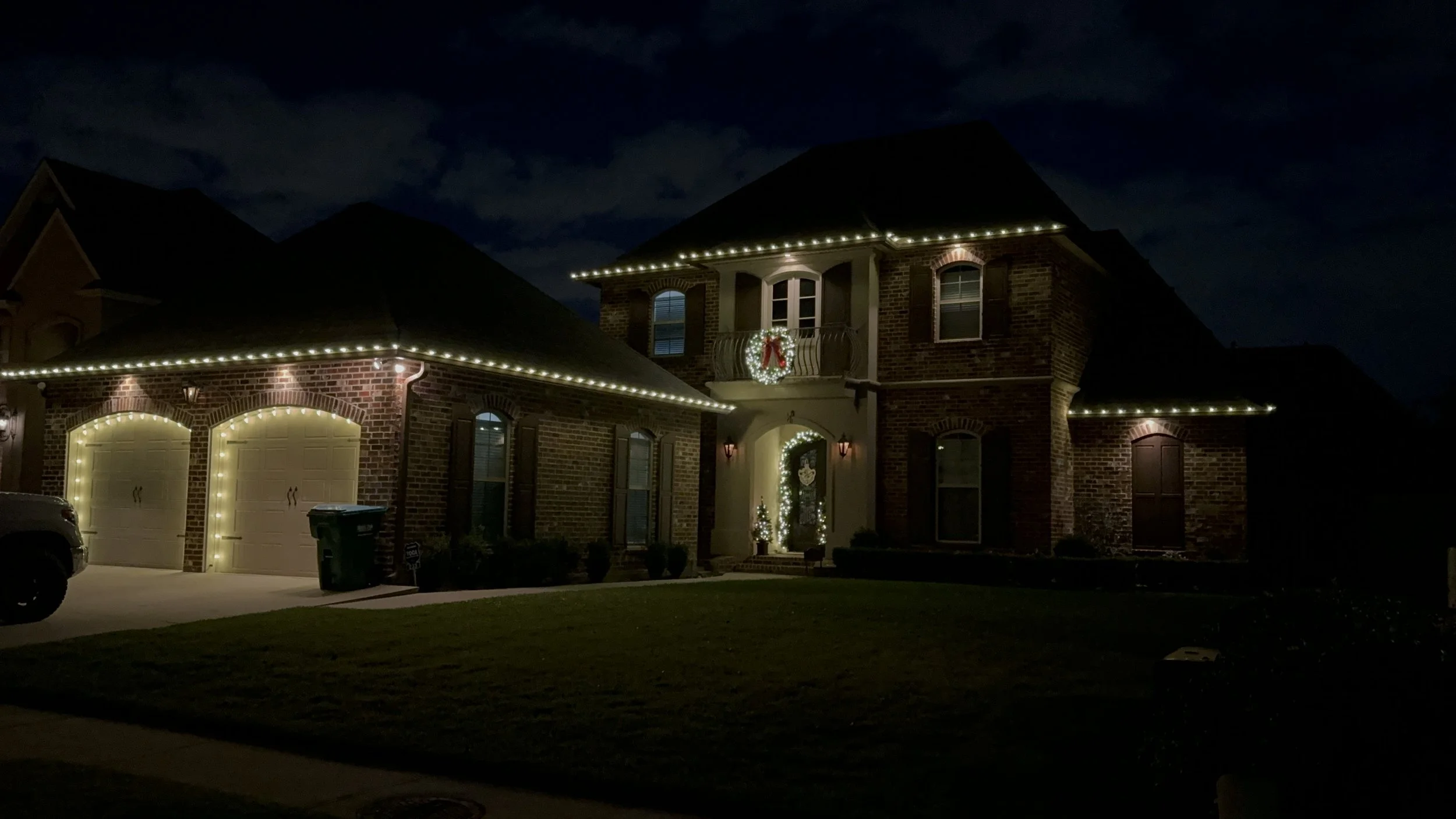 warm-white-christmas-lights-brick-house-balcony-wreath.JPG