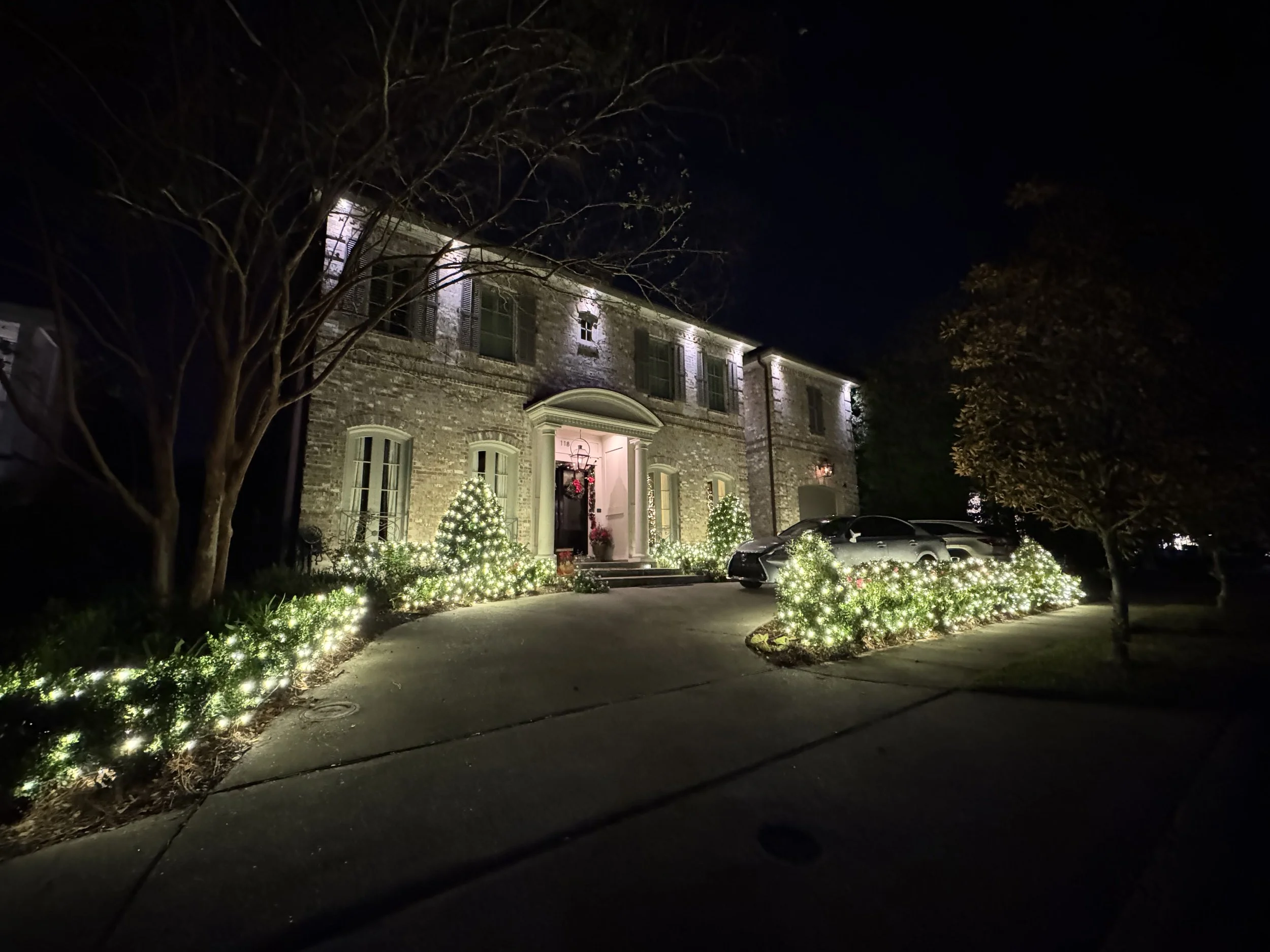 white-christmas-lights-brick-house-shrubs.jpg