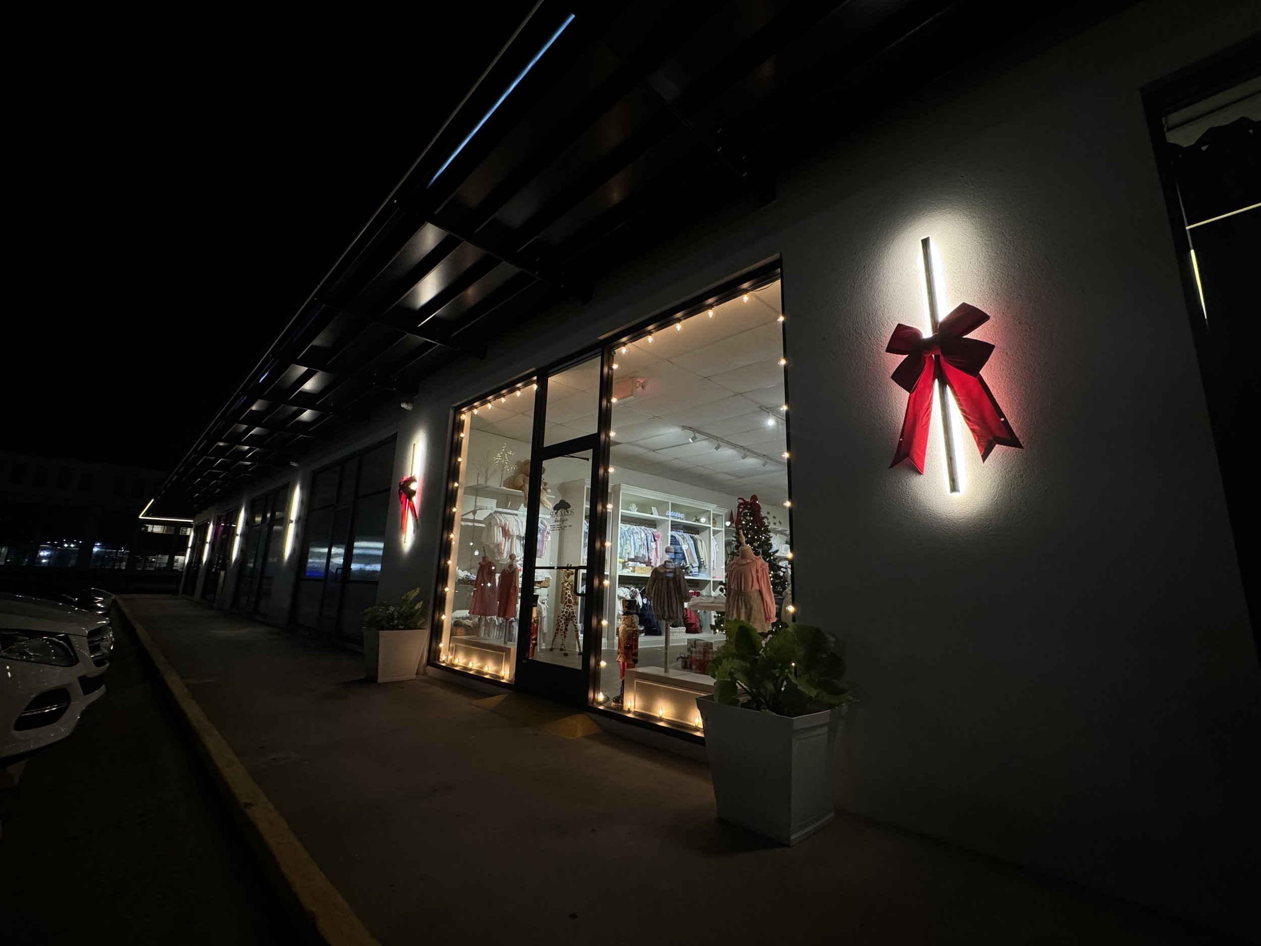 warm-white-lights-boutique-storefront-red-bow-at-night.jpg