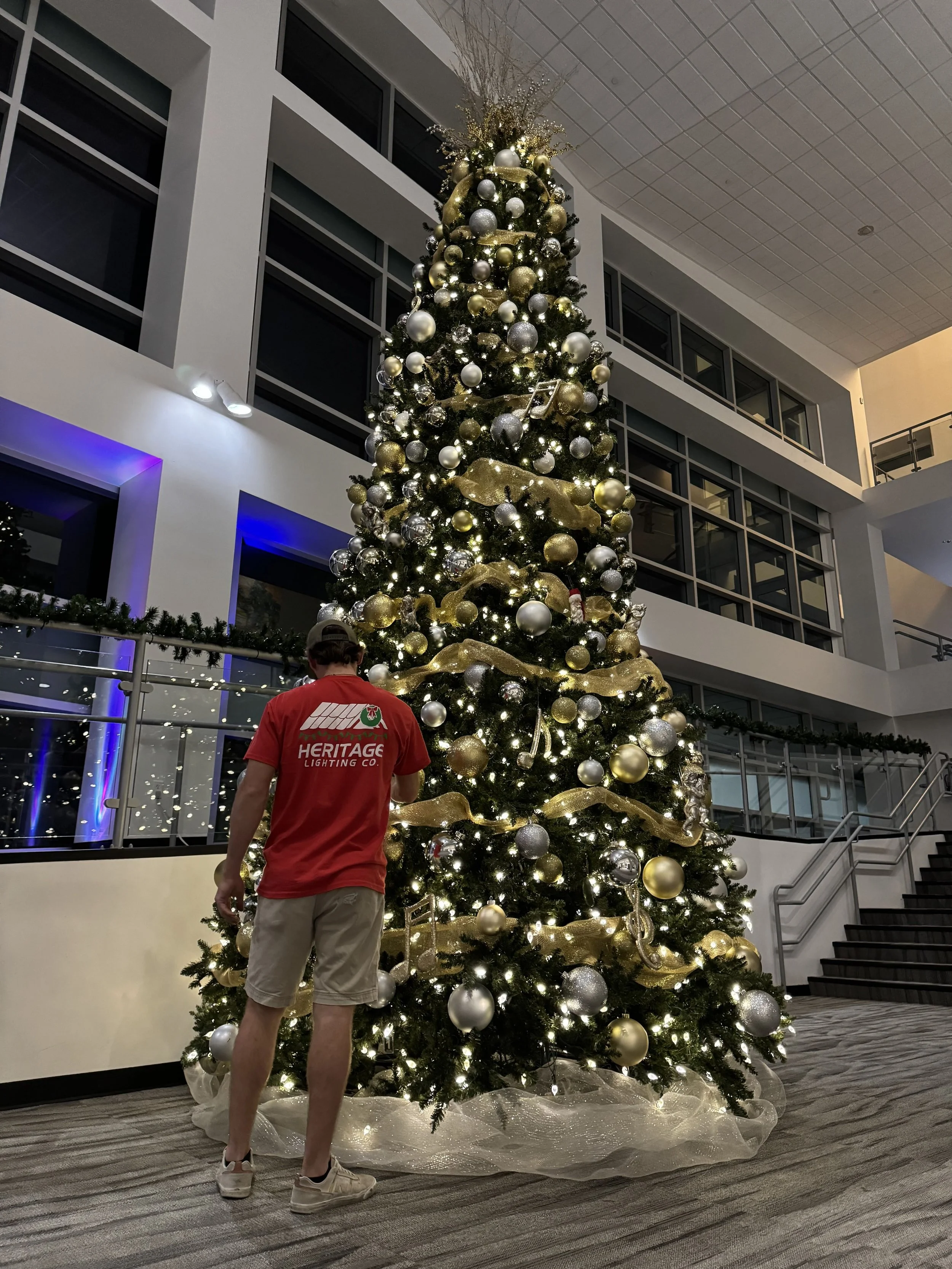 heritage-team-member-with-decorated-commercial-christmas-tree.jpg