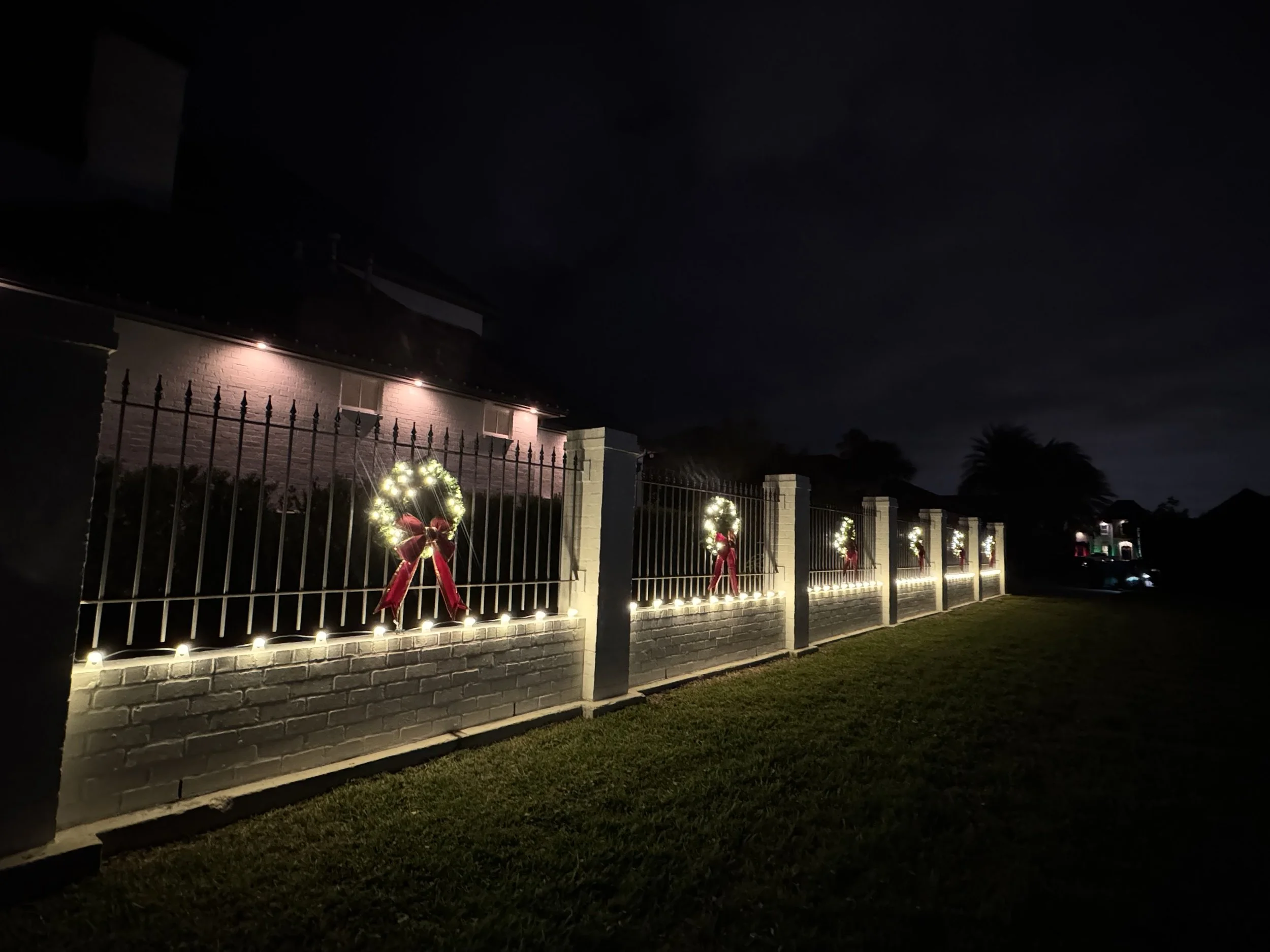 warm-white-lights-brick-iron-fence-wreaths.jpg