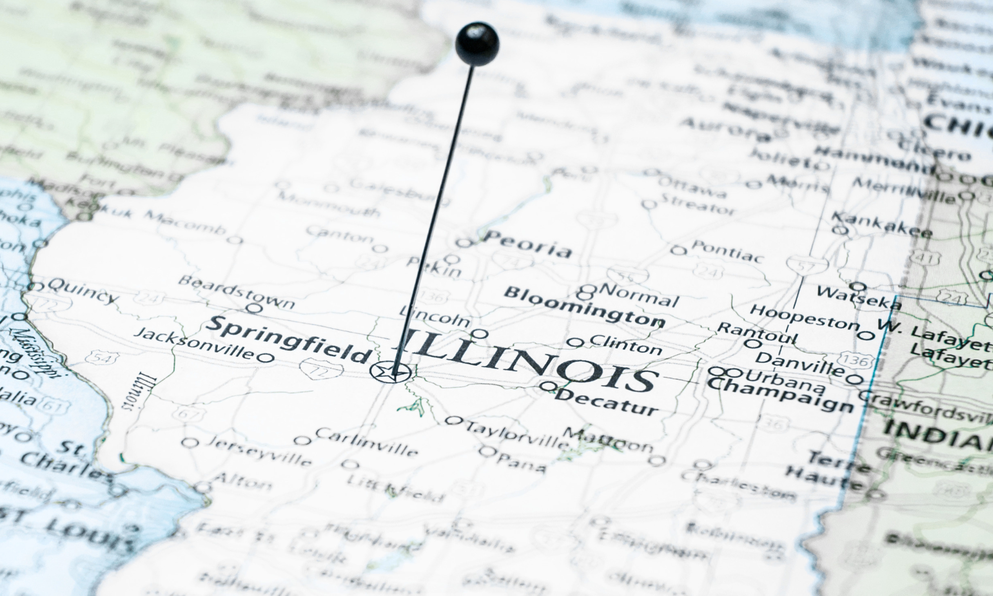 Close-up view of a map of Illinois with a black pushpin marking a location.