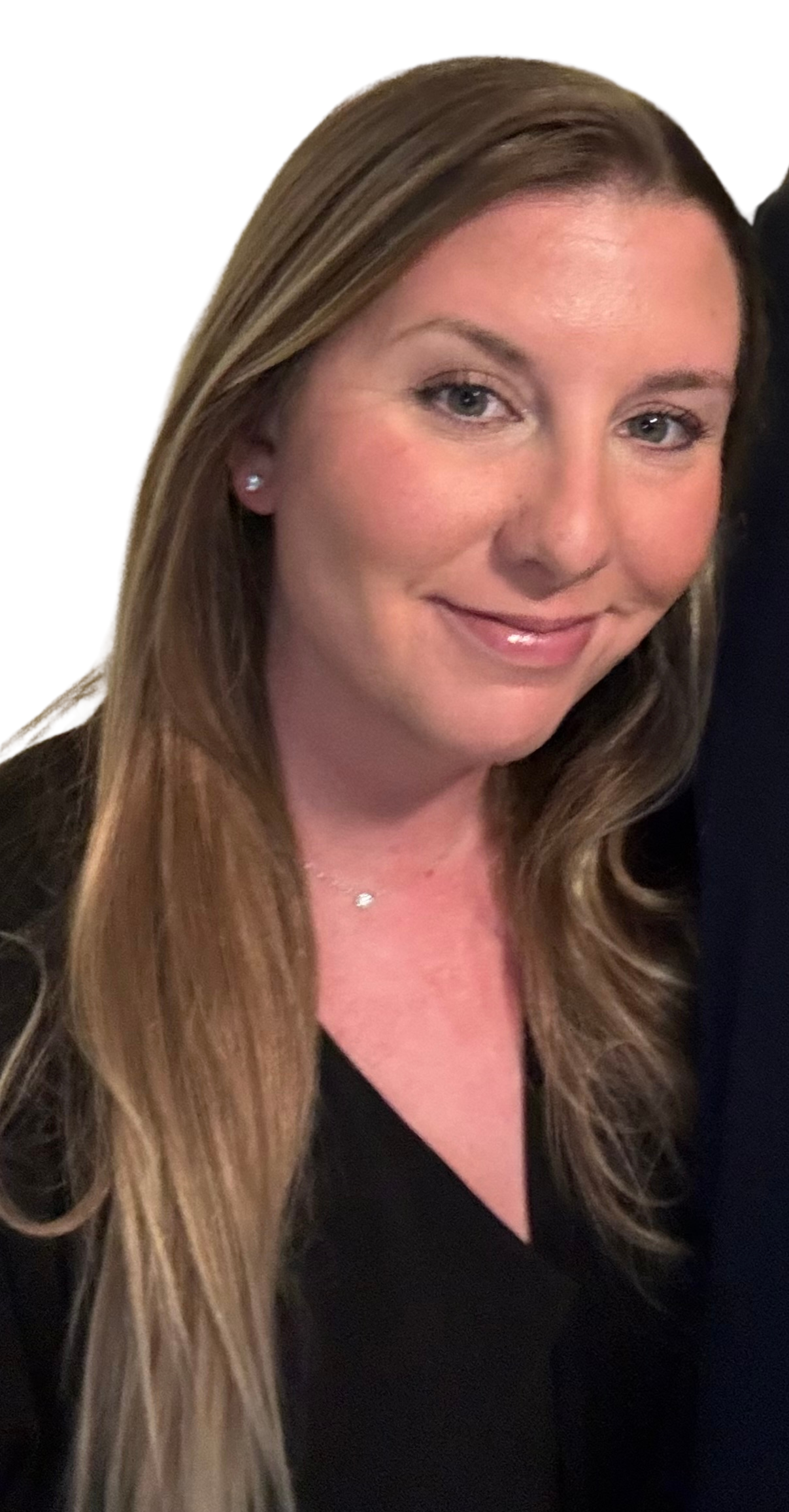Close-up of a woman with long, wavy, light brown hair, wearing small earrings and a delicate necklace, smiling softly.