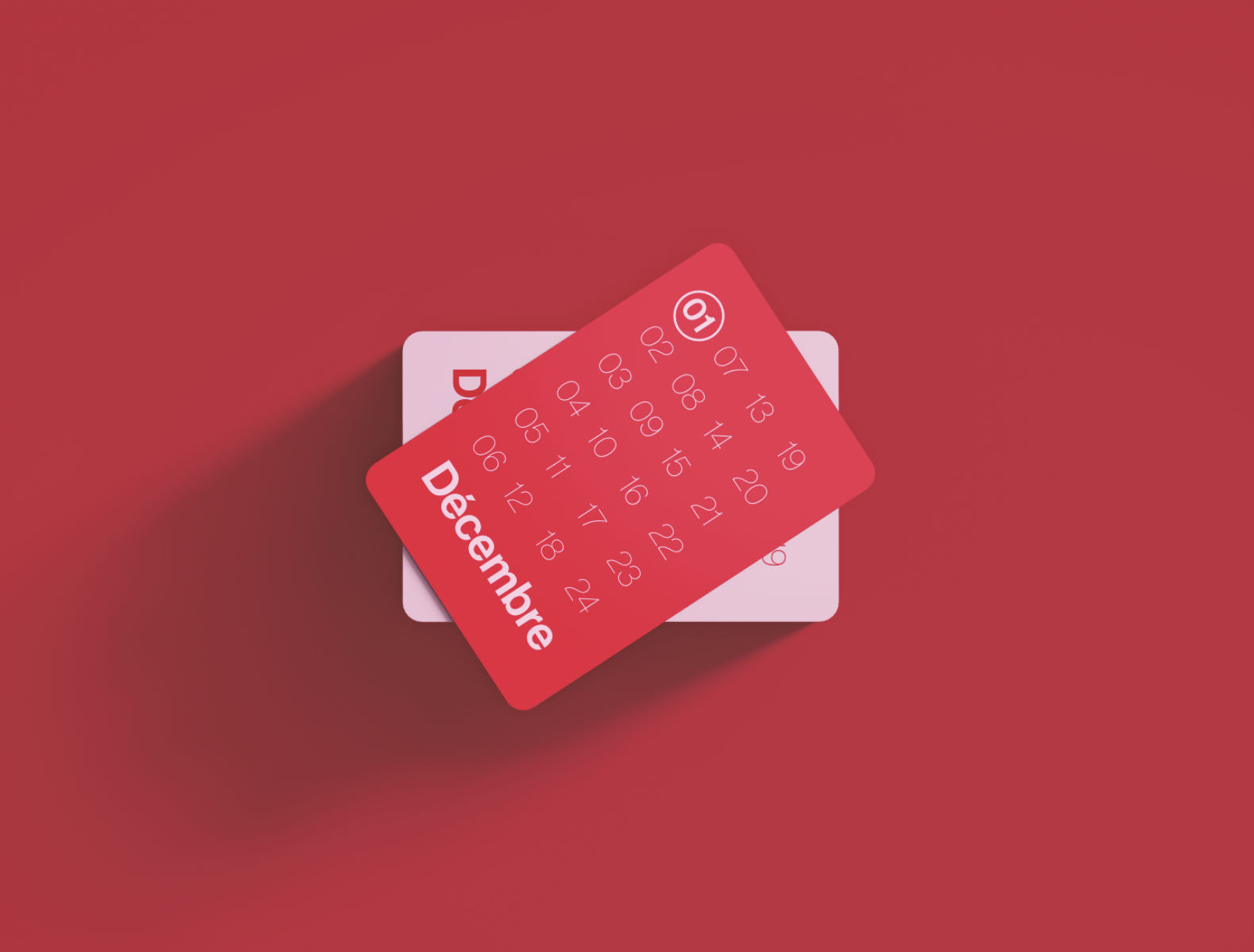 Un calendrier de décembre illustré par un billet rouge avec les dates du mois affichées, posé sur une surface rouge.