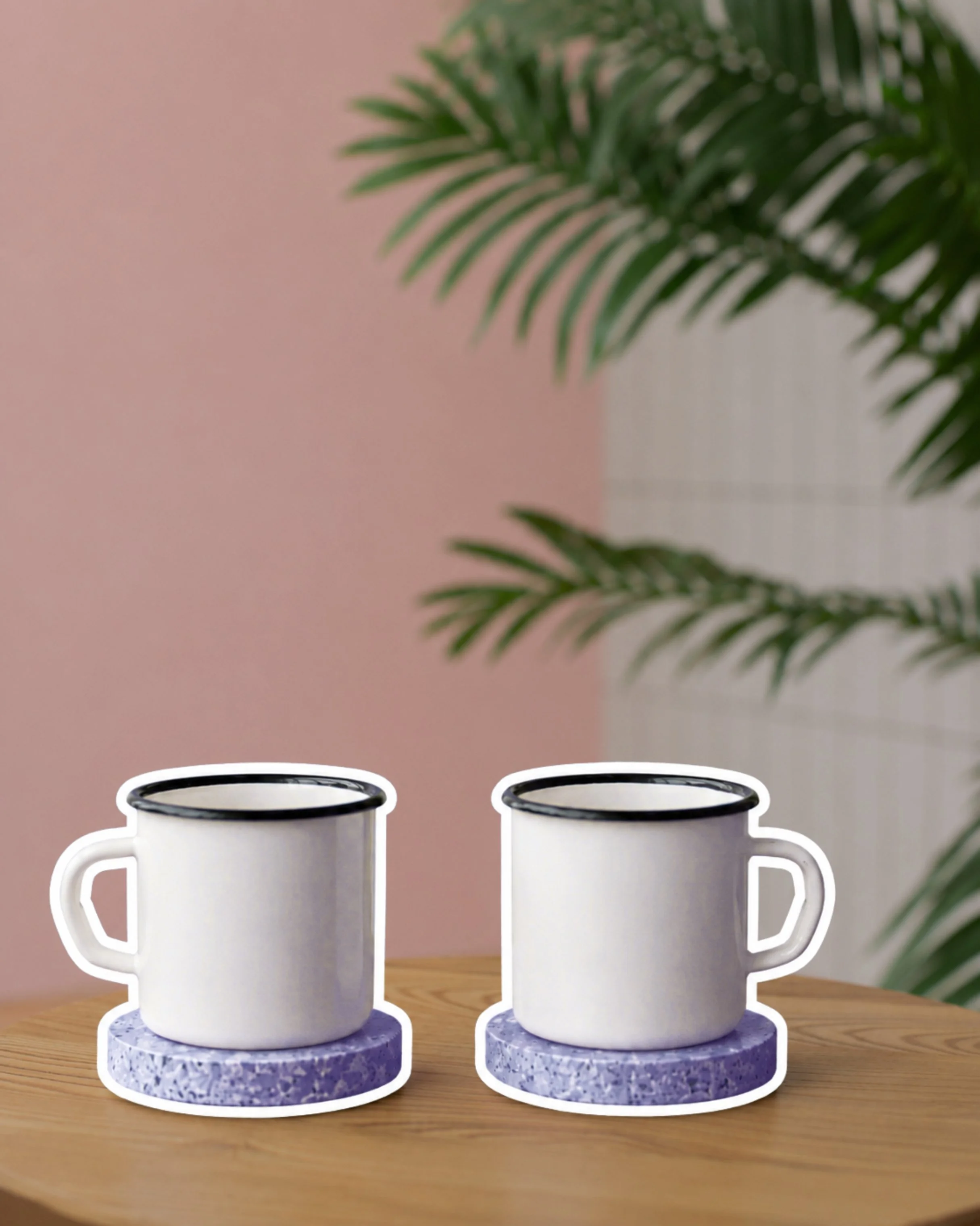 Two white coffee mugs with black rims and handles on a blue circular stand, placed on a wooden surface, with green fern leaves in the background.