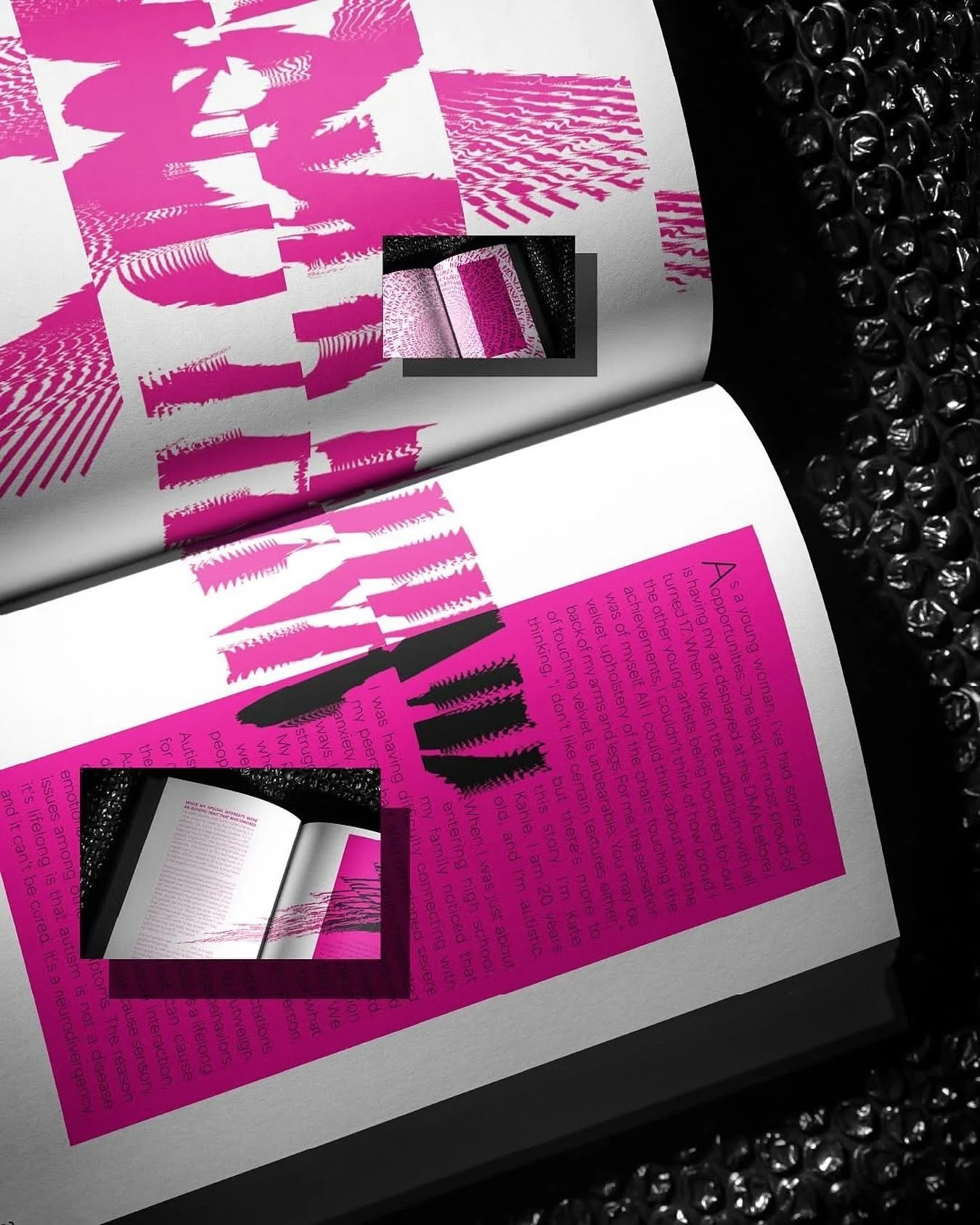 Open magazine with pink and black graphic design, including bold text and pages with printed text, surrounded by bubble wrap.