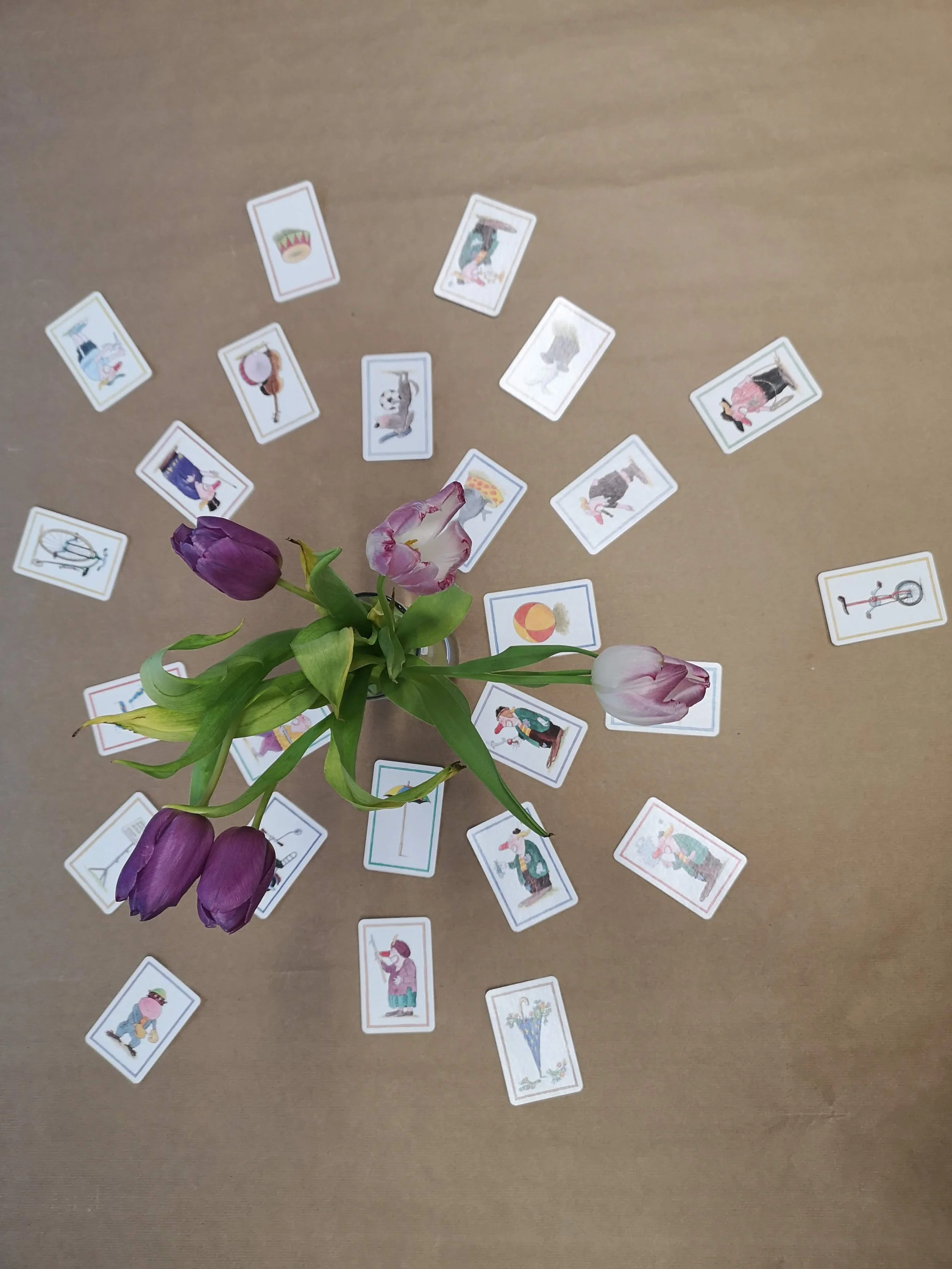 Blumenstrauß mit Tulpen auf einen Tisch, umgeben von vielen Spielkarten