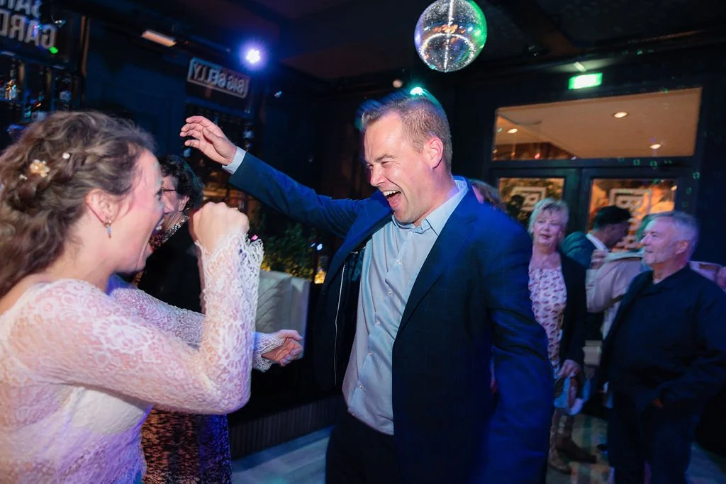 People dancing and celebrating at a party, with a man and woman laughing and enjoying themselves.