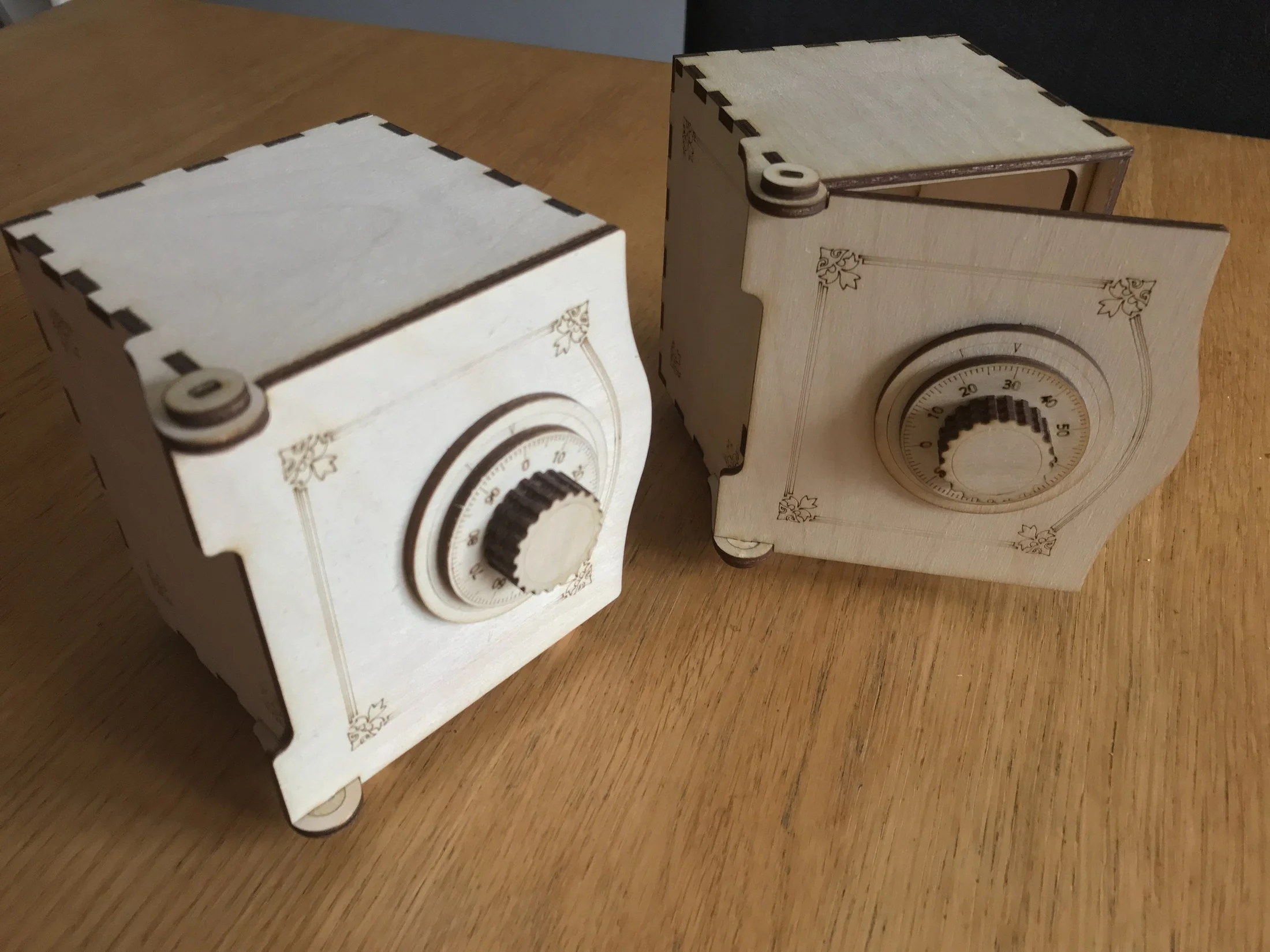 Two wooden dial boxes, including one with the door open.