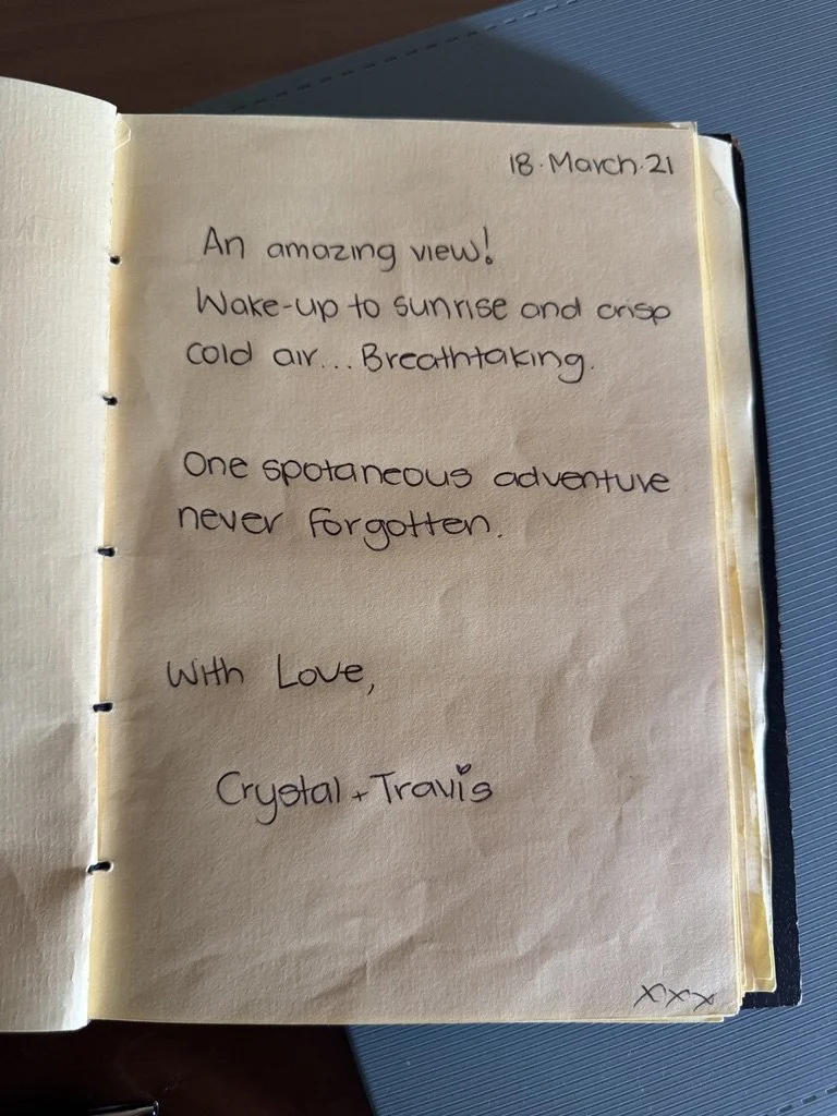 A handwritten journal entry dated March 18, 2021, expressing admiration for a beautiful sunrise view and recalling a memorable adventure, signed by Crysta and Travis.