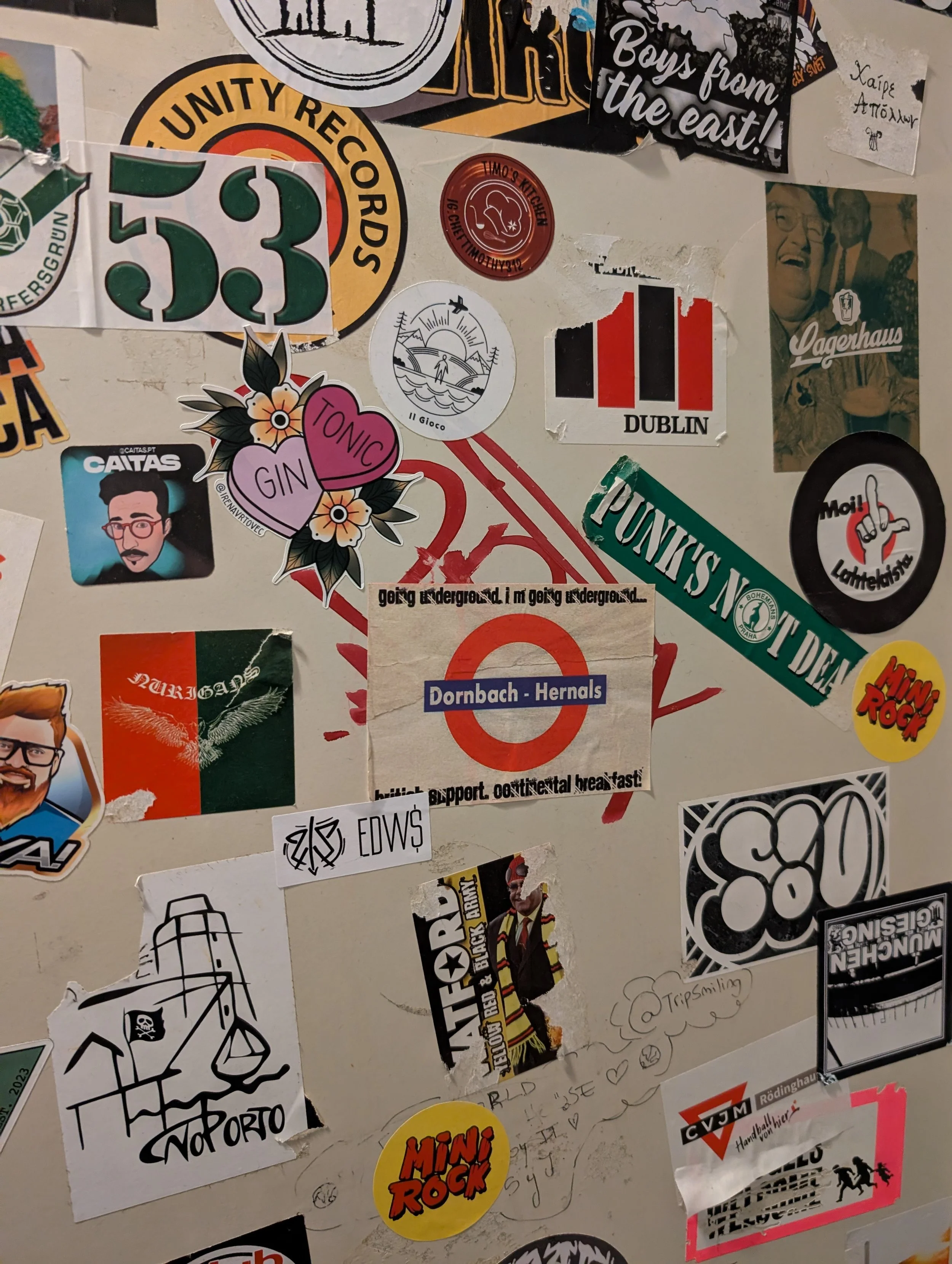 A collage of various stickers, including flags, cartoon characters, band logos, and miscellaneous art and graffiti symbols.