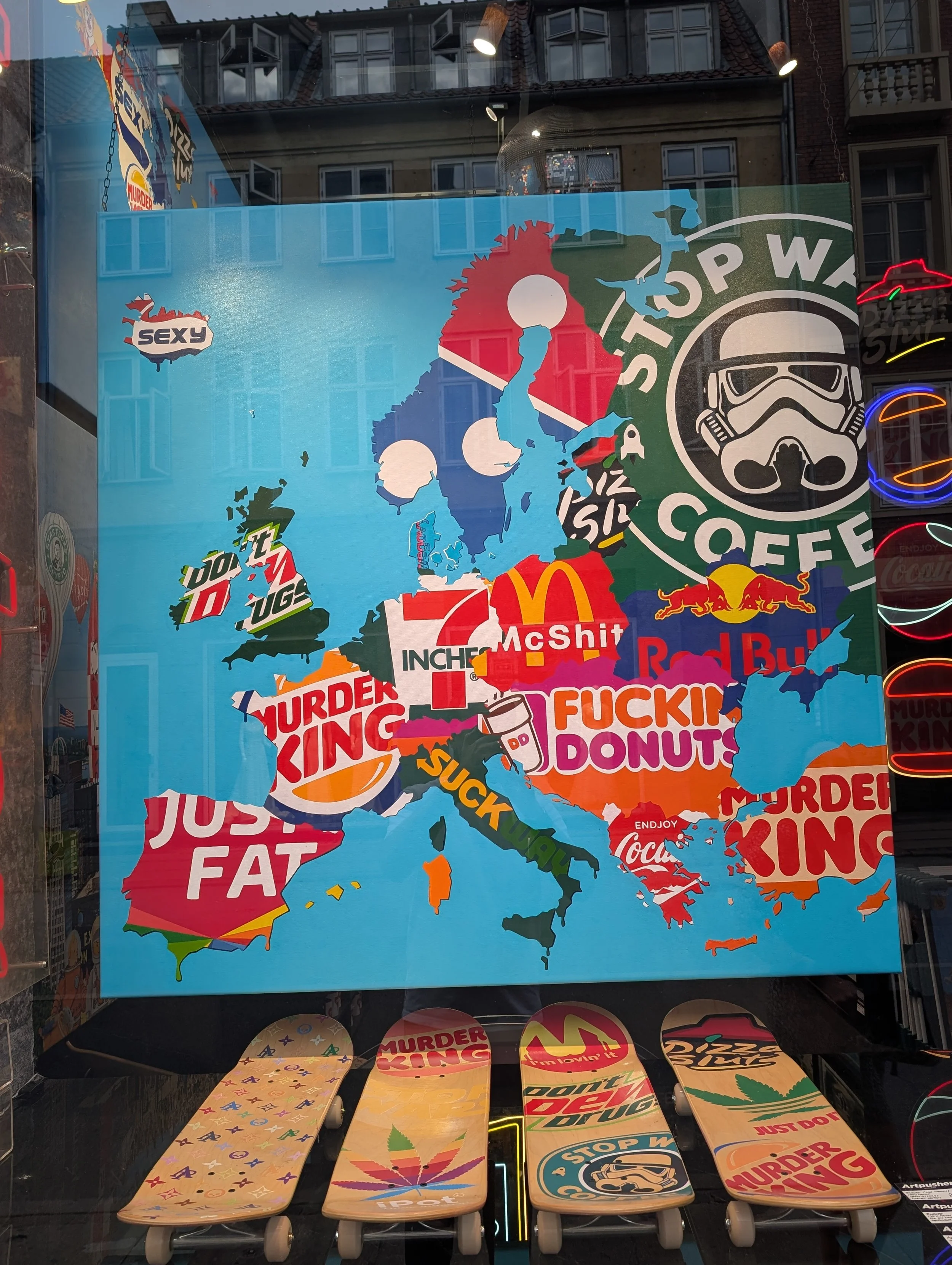 Colorful illustration of Europe with stickers featuring popular brands, symbols, and phrases in a collage style, including a Stormtrooper mask, the Red Bull logo, a marijuana leaf, and various humorous phrases and logos.