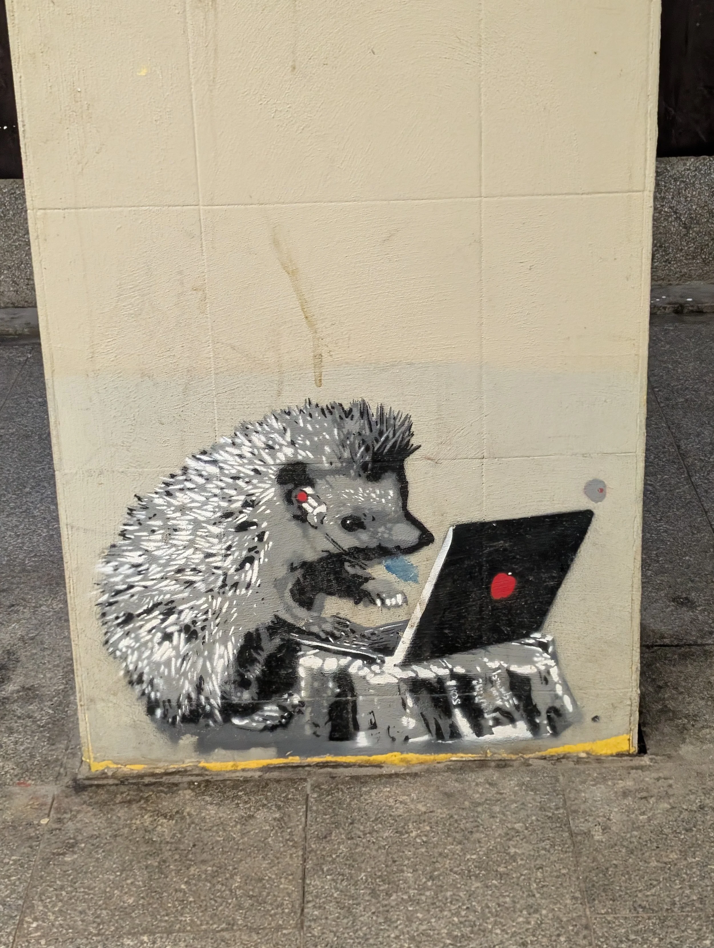 Street art of a hedgehog looking at a laptop with a red heart on the screen