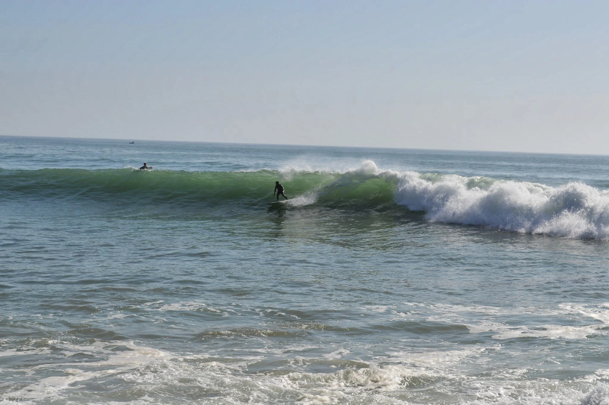 A person surfing on a wave in the ocean during the daytime.