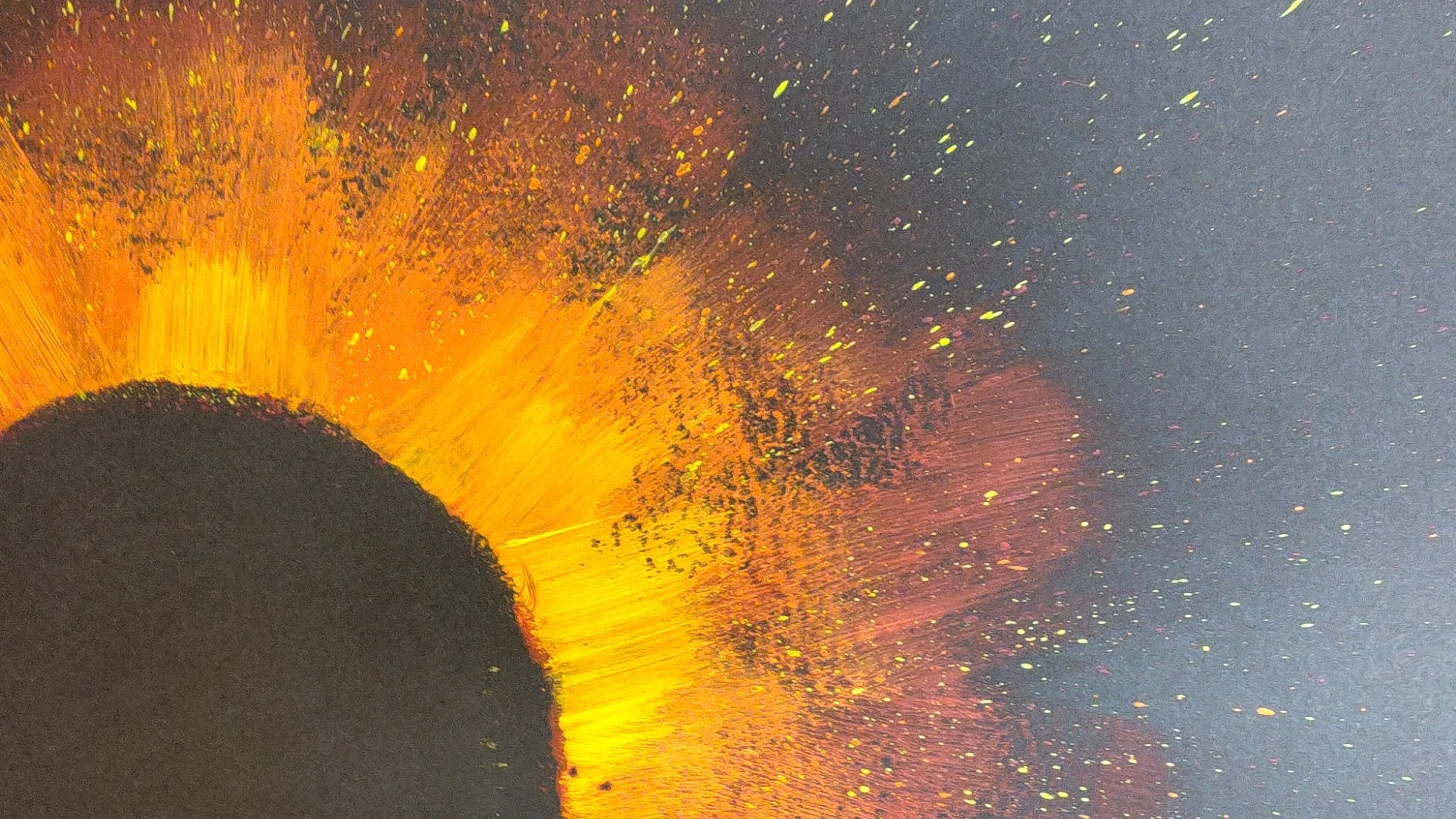 Close-up of 'VOID RED', original abstract painting, depicting a matte black central circle rimmed with a fiery, textured explosion of red, orange, and fine gold strokes and specks against a black background.