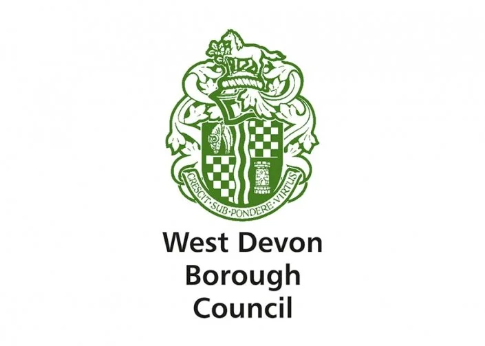 Logo of West Devon Borough Council featuring a green crest with a lion, shield, and a banner, accompanied by the text 'West Devon Borough Council'.