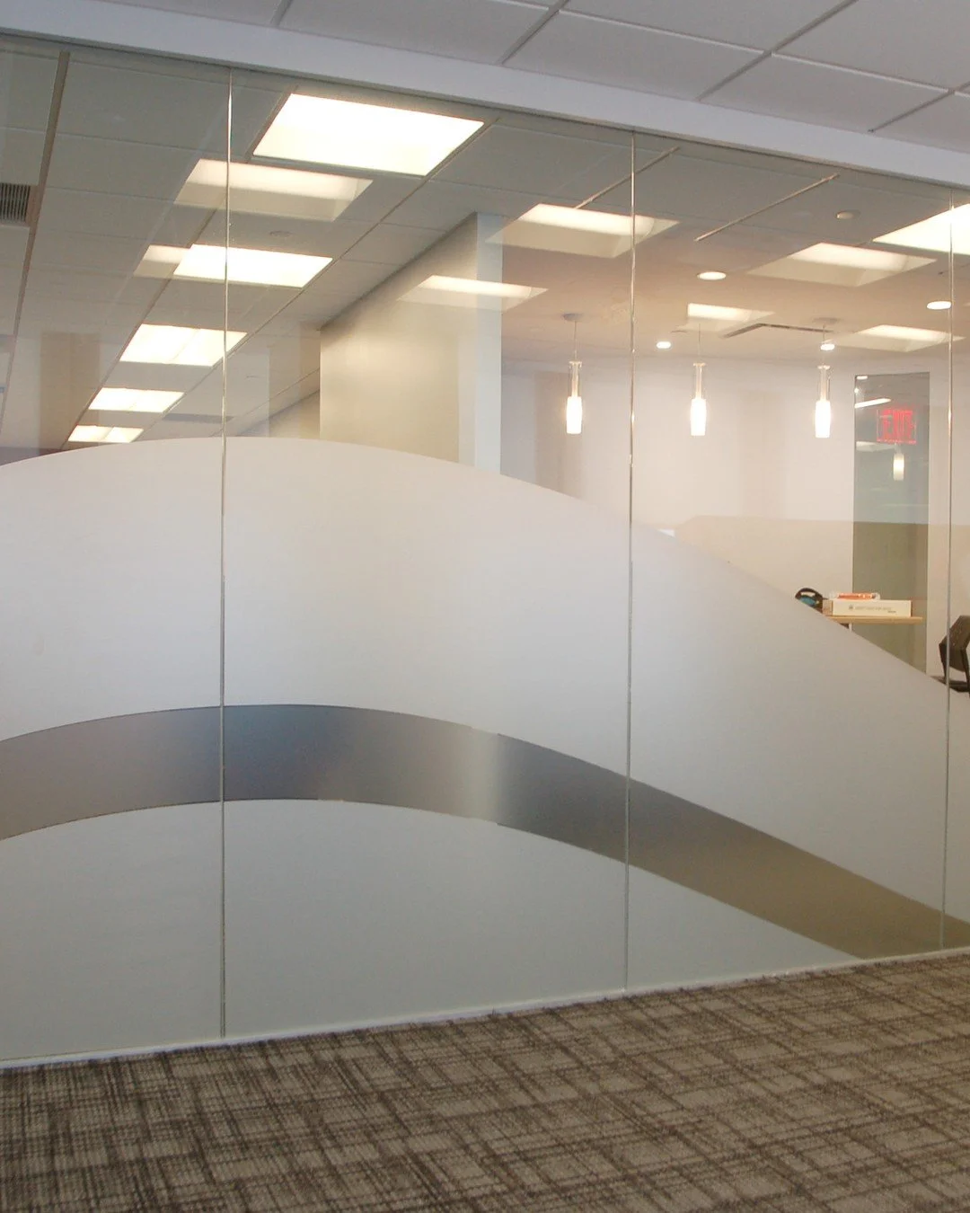 On this project, 3M Fasara Milano, a milky white frosted film, was cut into a sweeping shape across the glass wall, providing privacy where the office needs it. Custom designs can also be printed on 3M Fasara clear film on our SwissQprint.

See the F