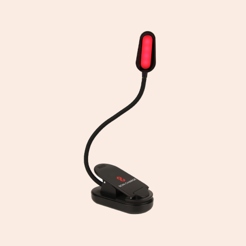A black reading clip light with the BonCharge logo on its base and the "arm" of the light snaking up vertically — red light visible. On a pink-ish background.
