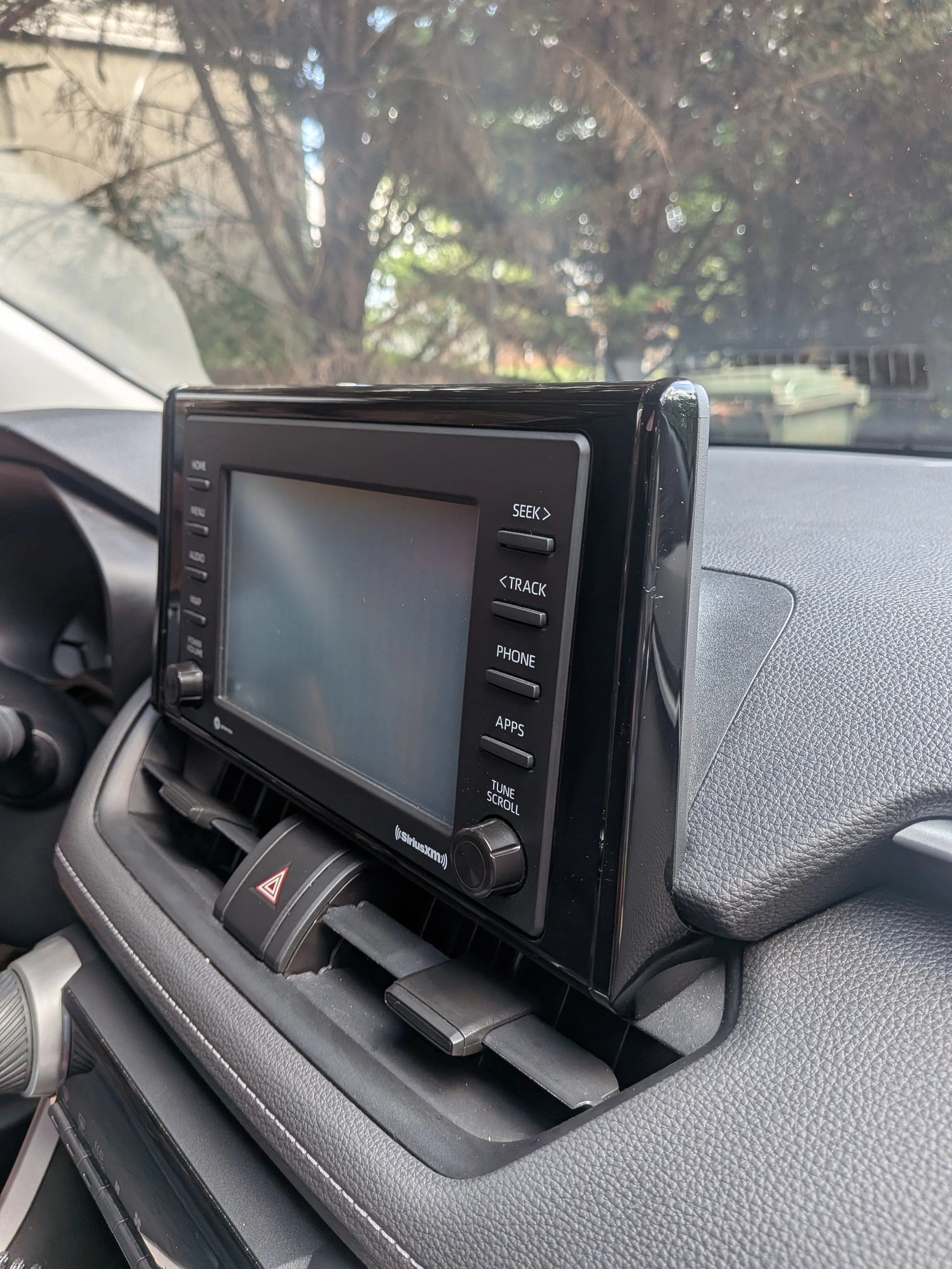 The photo shows a Toyota dashboard with the infotainment screen in the center