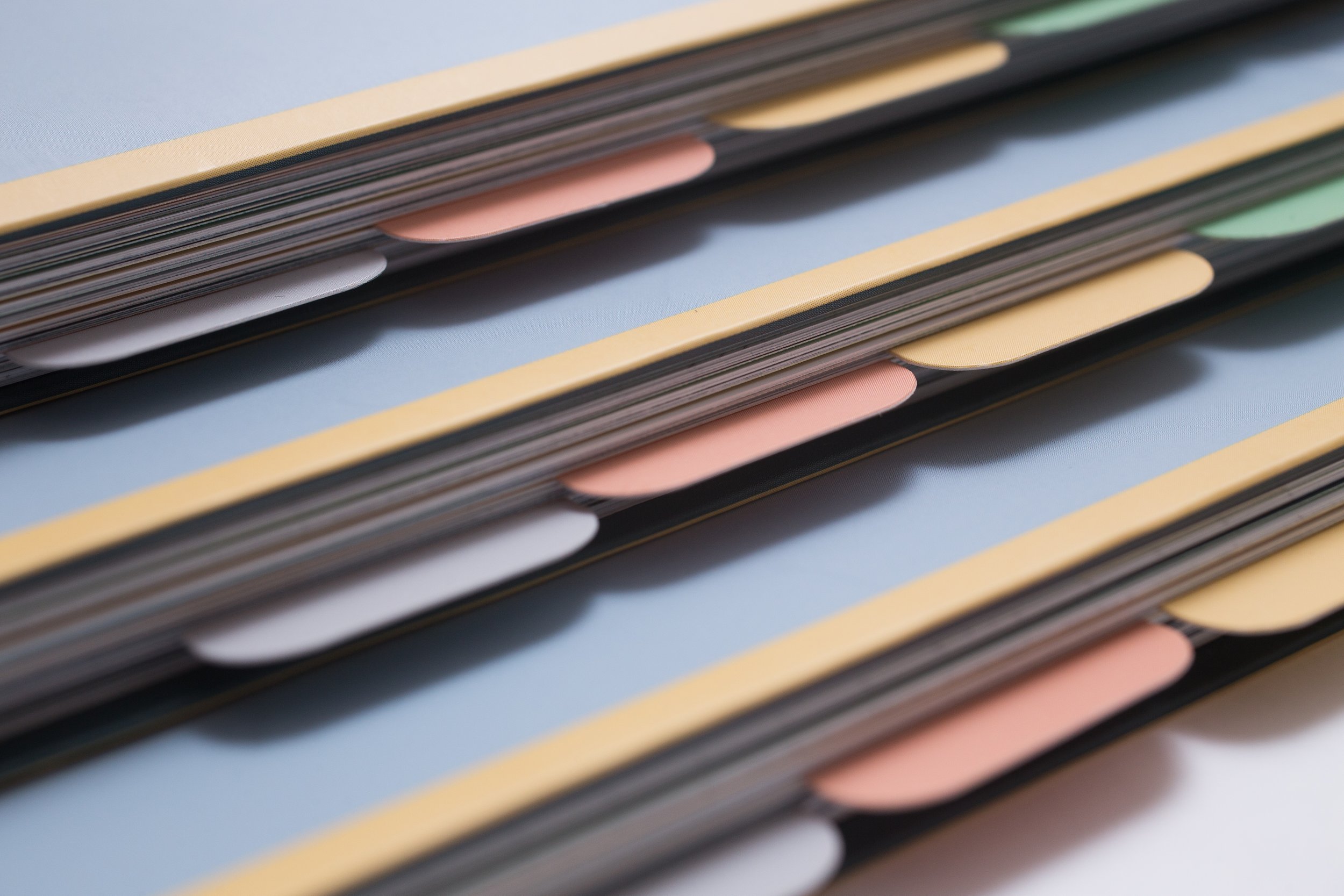 Detail of three guides on a stack showing the coloured tabs on the spine.
