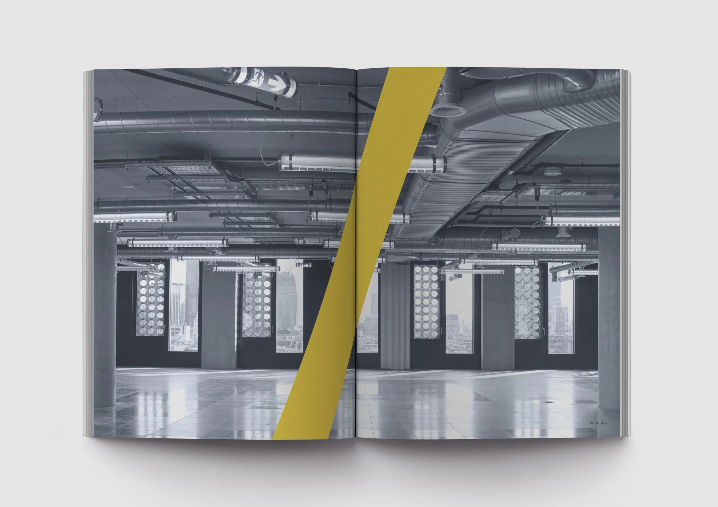 Fit Out Rip Out image spread with a building image and a yellow thick slash in the middle of the spread.