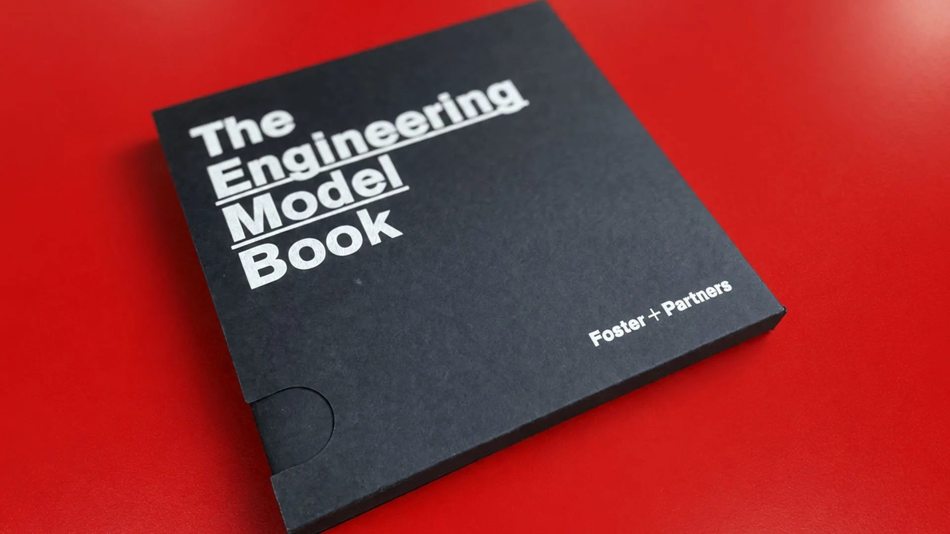 Cover of a book titled 'The Engineering Model Book' by Foster + Partners on a red background.