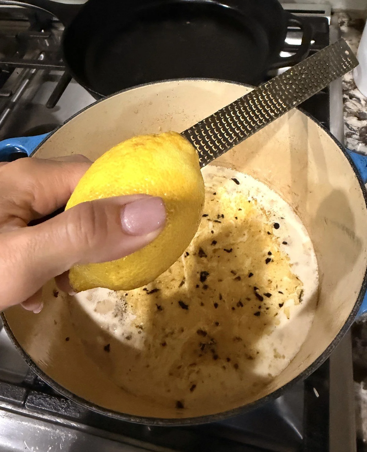 Zesting a lemon over a Dutch oven
