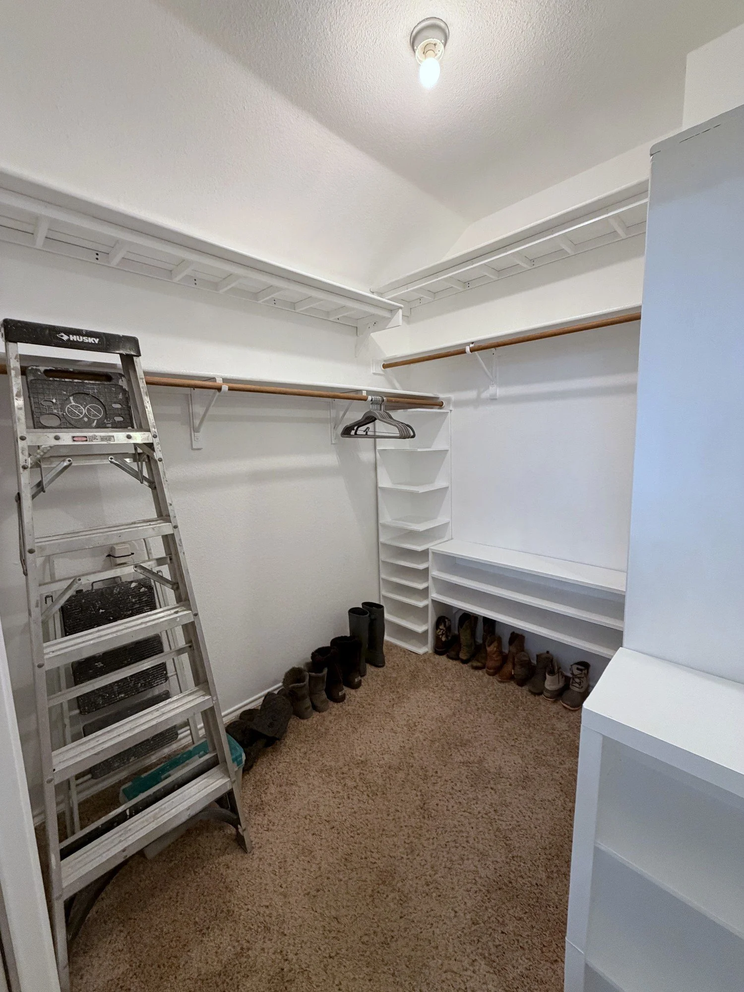 empty, freshly painted closet with new shelving installed.