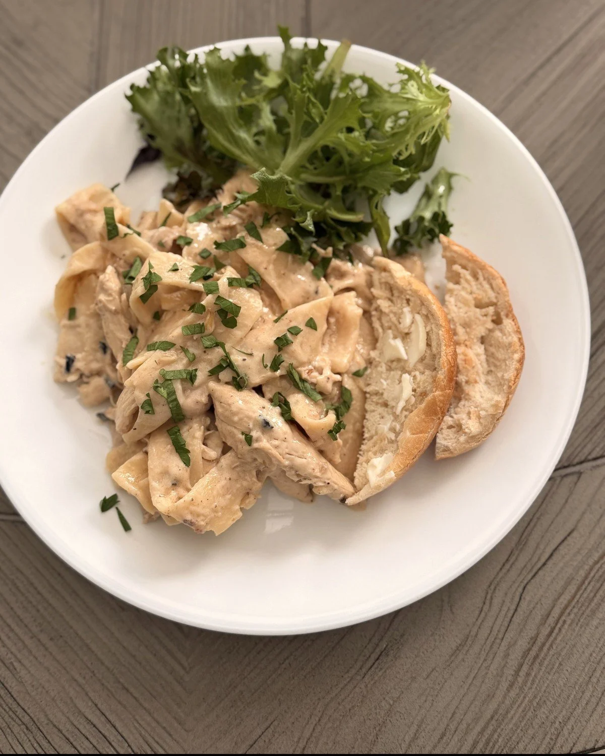 Creamy chicken pappardelle with parsley, salad greens and buttered French bread
