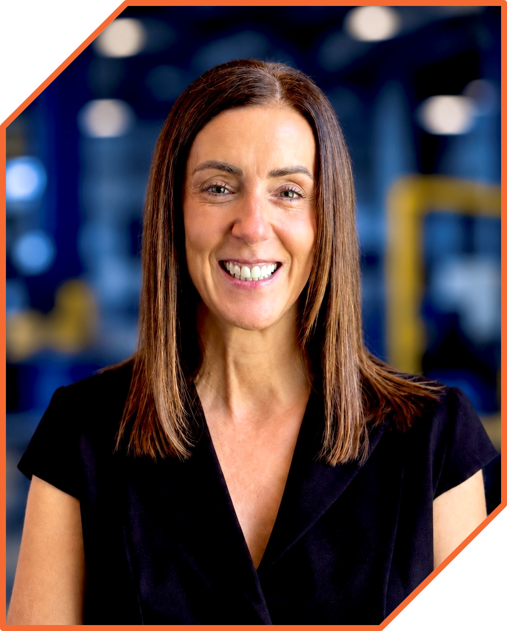 Woman smiling in an indoor gym or fitness center.