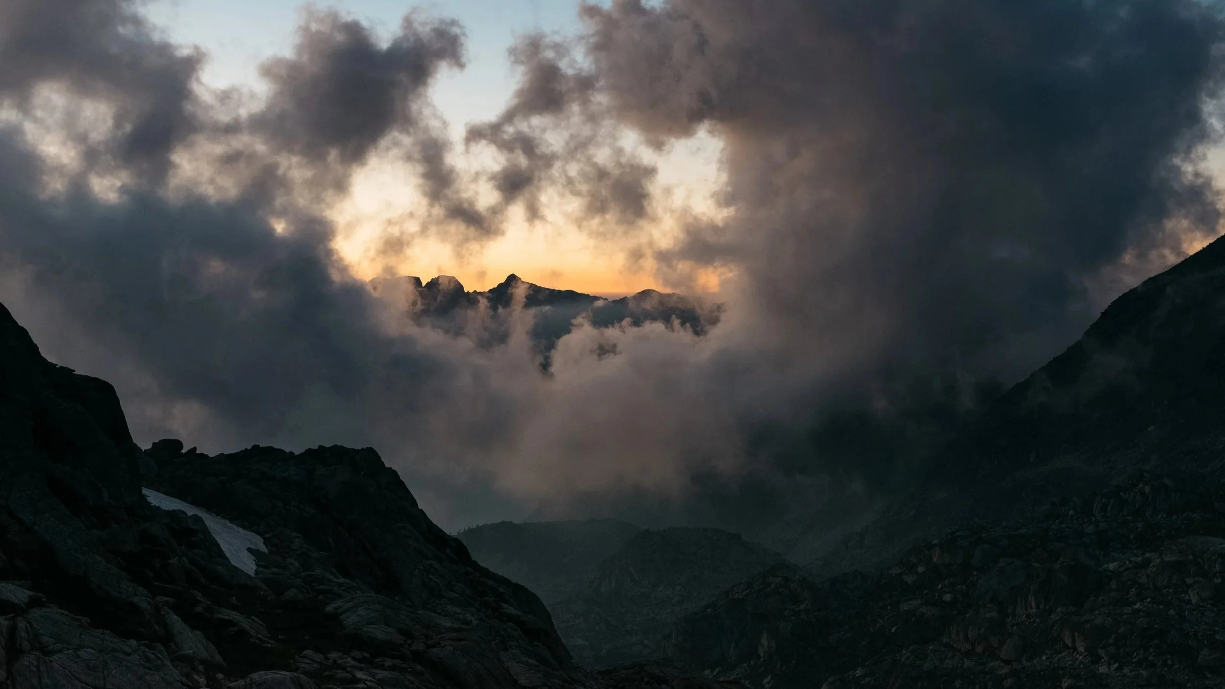 Paysage de montagnes avec nuages sombres au coucher du soleil.