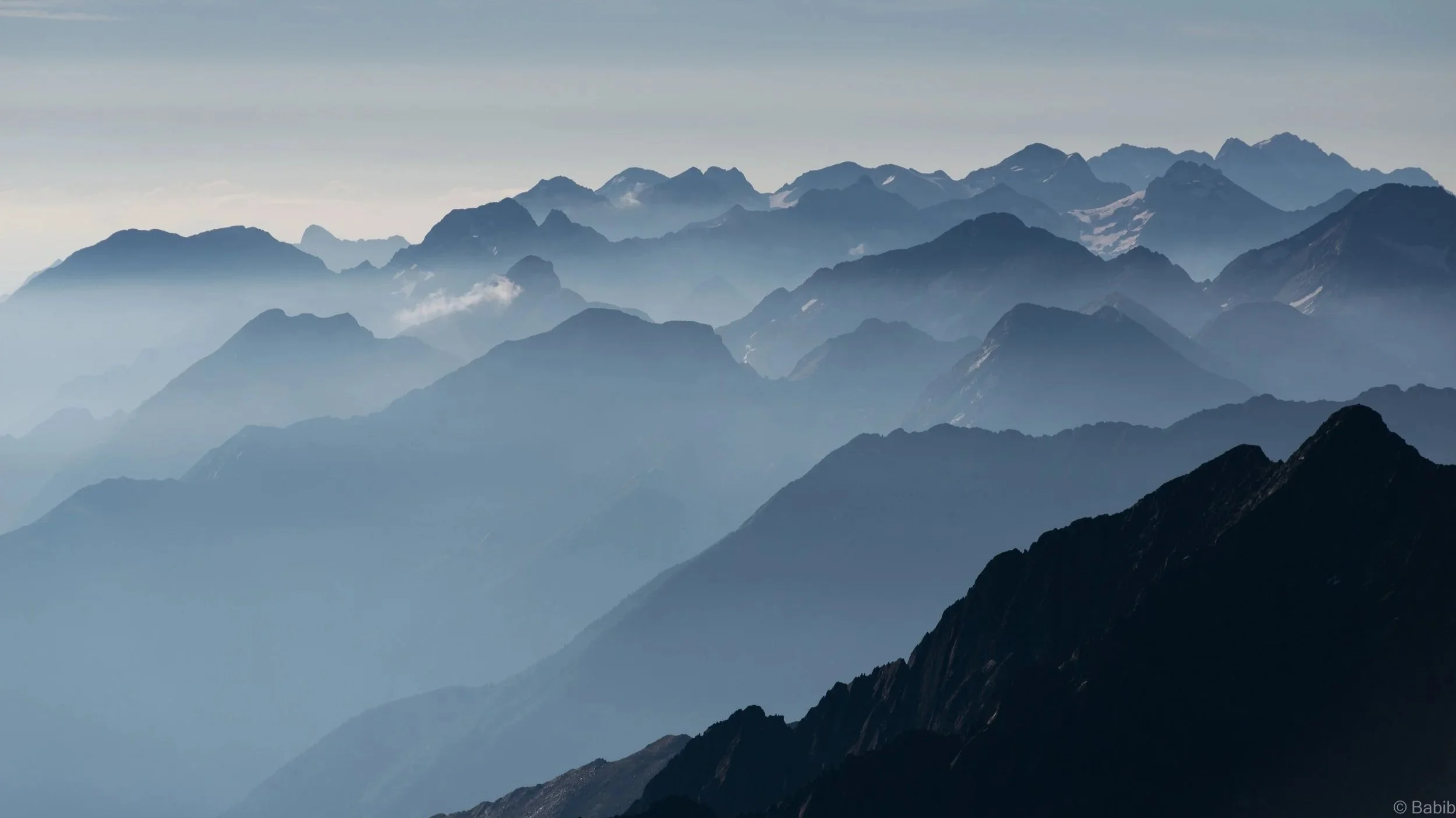 Chaînes de montagnes en arrière-plan avec des nuages et une brume légère