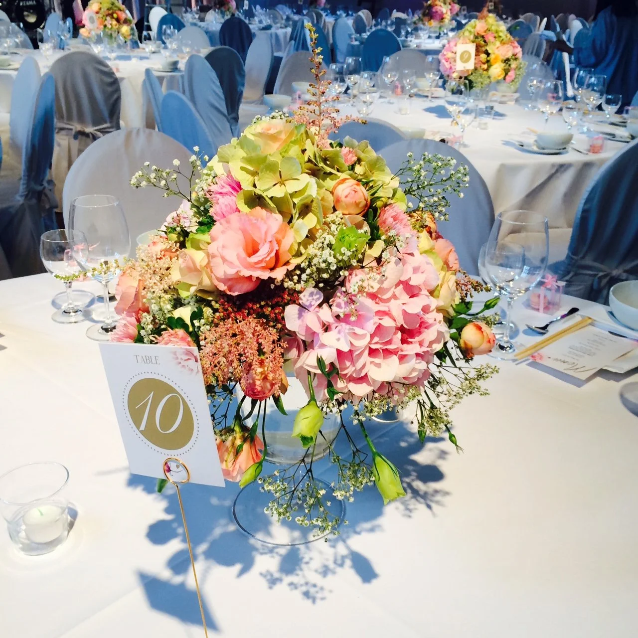 Festlich gedeckter Hochzeitstisch in der Schinkelhalle Potsdam mit üppiger floraler Tischdekoration.