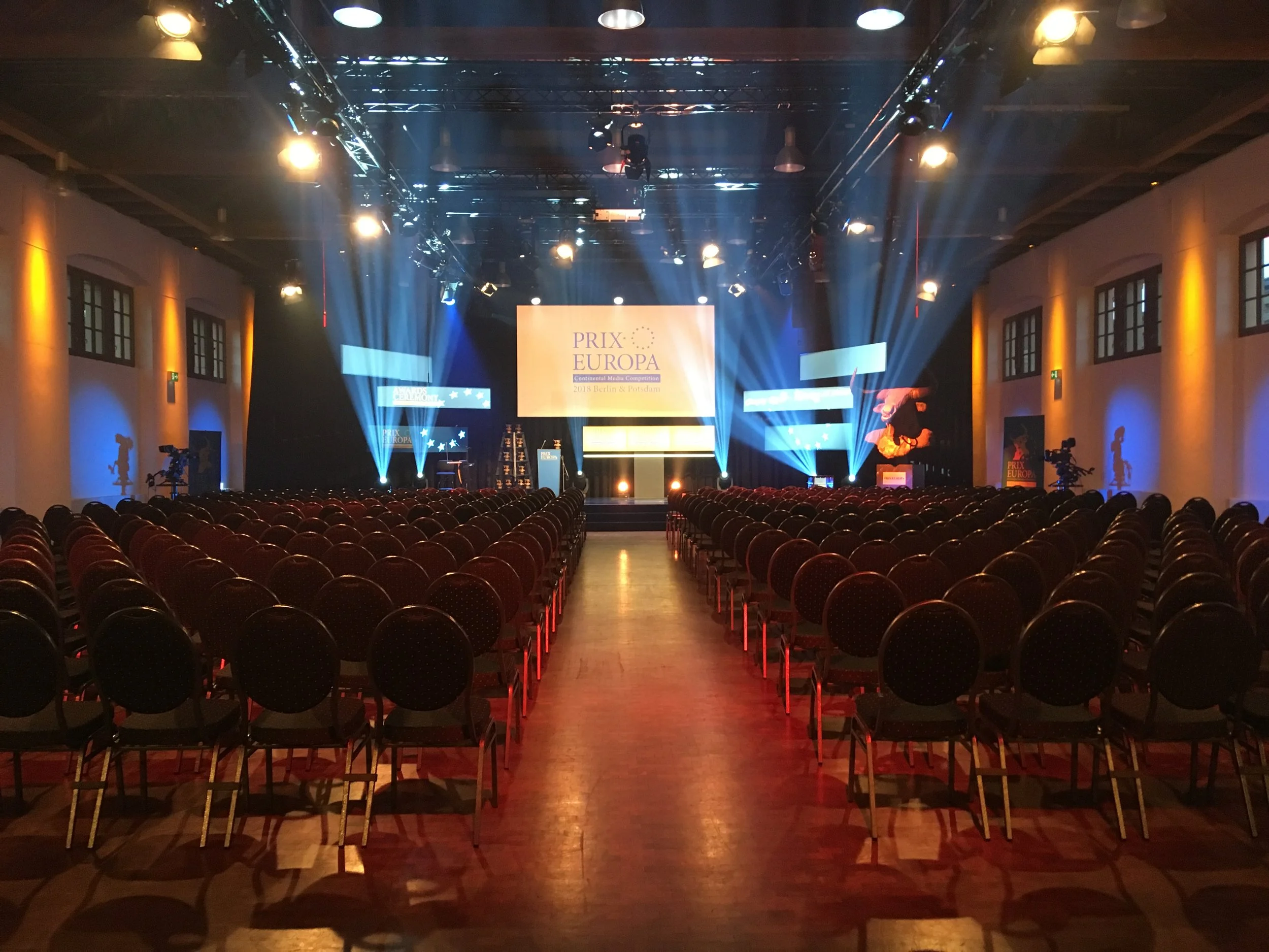 Festakt in der Schinkelhalle Potsdam mit Reihenbestuhlung, Bühne, Projektion und Lichtinszenierung.