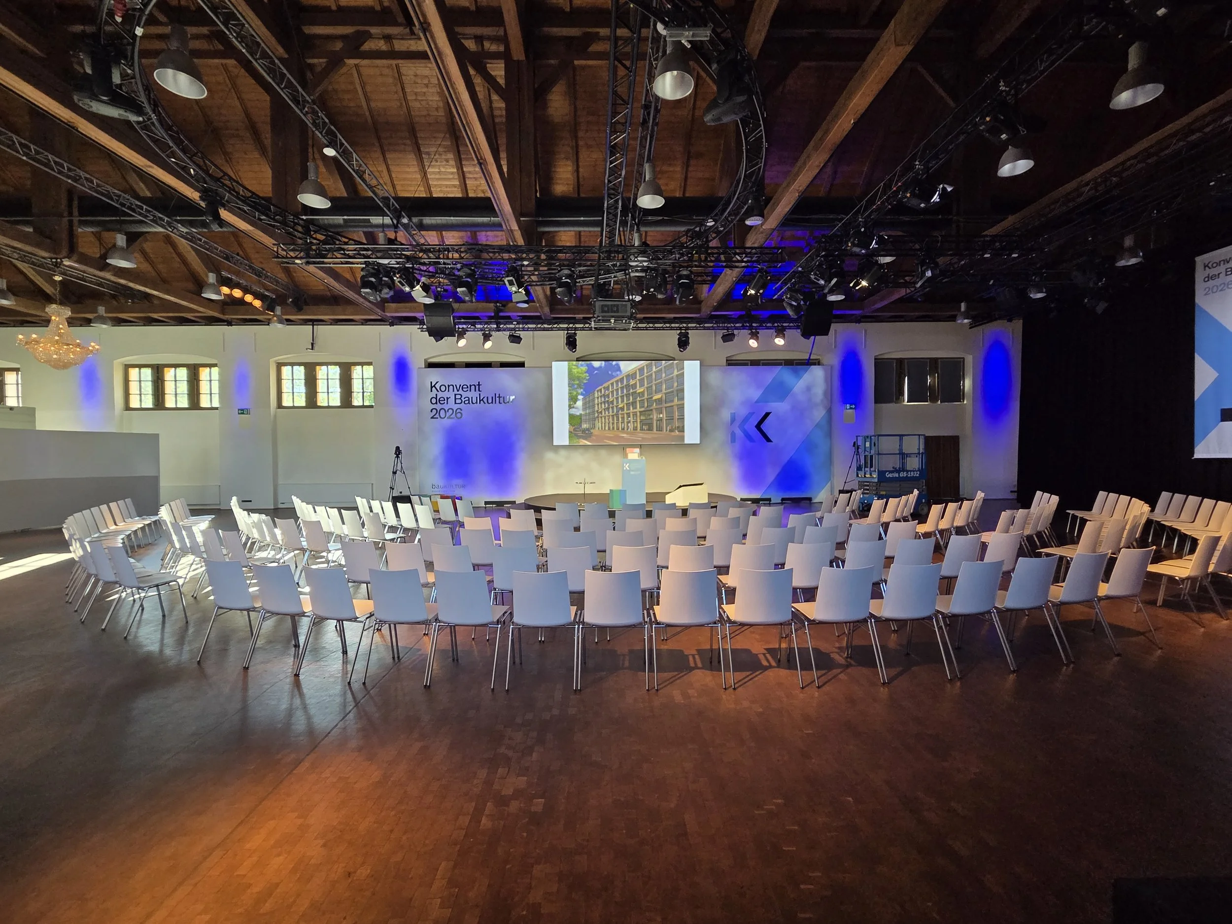 Konferenz in der Schinkelhalle Potsdam mit Reihenbestuhlung, Bühne, Präsentationsfläche und sichtbarer Veranstaltungstechnik.