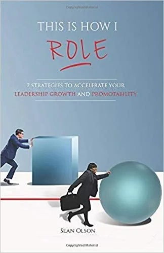 Book cover titled "This Is How I Role" by Sean Olson, with a man pushing a large cube and a woman pushing a large sphere.