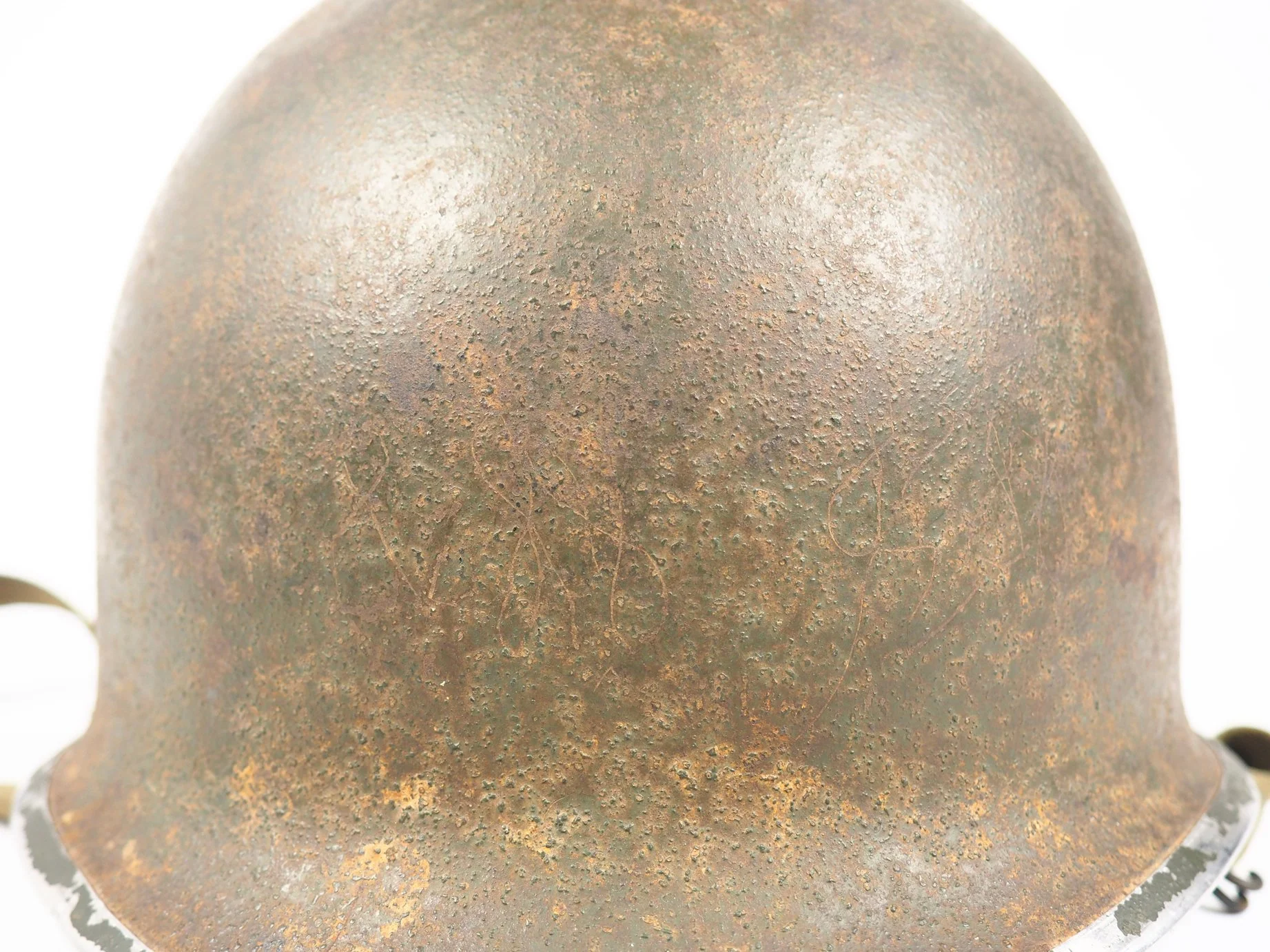 Unknown cursive inscriptions scratched onto the front of Stephen's helmet. I believe it may be his initials.