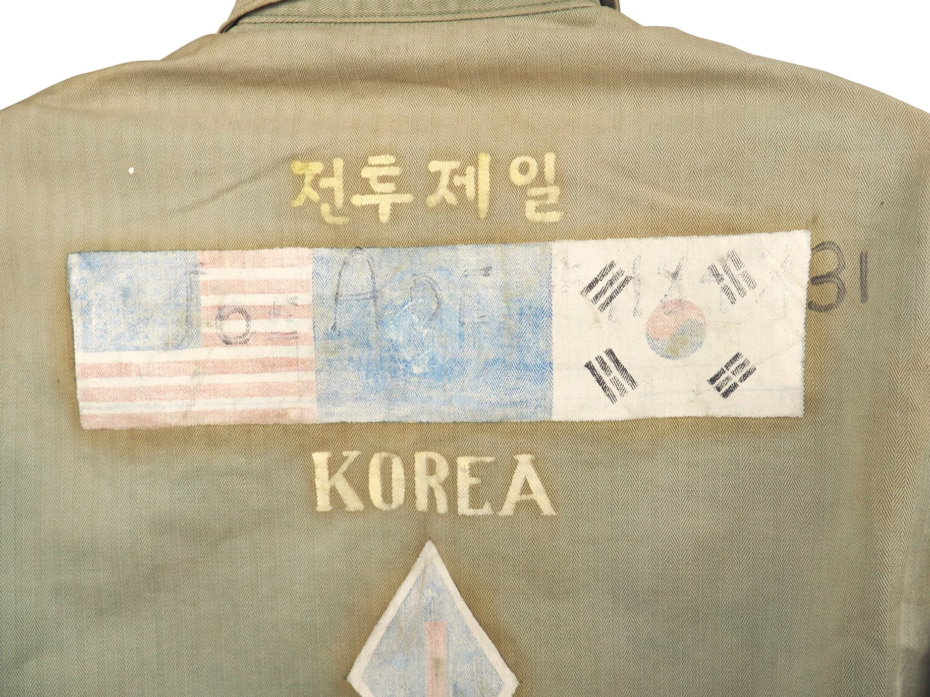 The US Flag, UN Flag, and Korean flag, flanked by 1st Marine Division insignia. Below the paint, we can see Joe Ade's name and service number. The Korean text roughly translates to "Combat First" or "First in Combat" which I assume is a nod Joe's uni