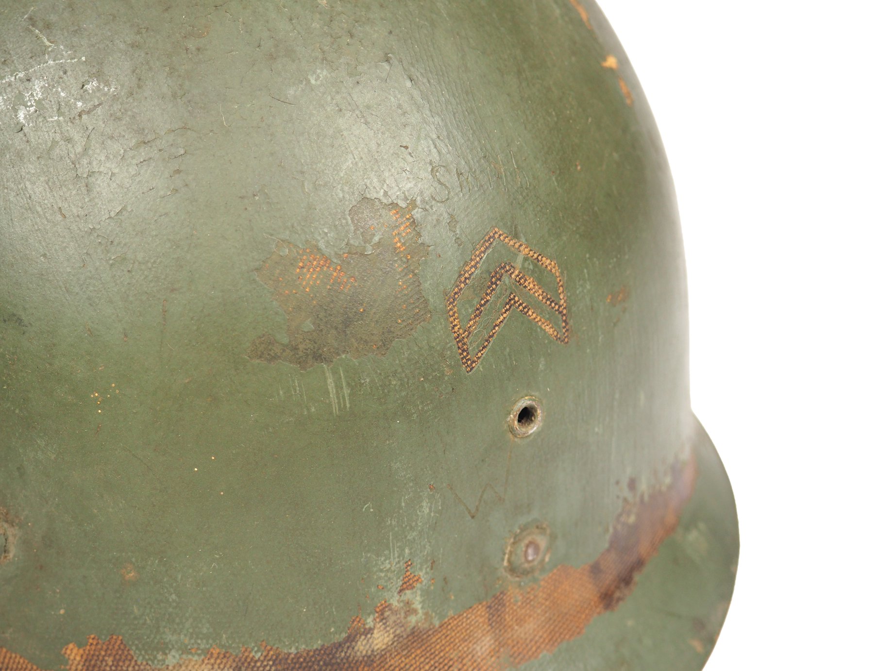 Corporal Smith scratched his last name and rank insignia on the front of his liner. The same shade of green paint on this liner can be seen on the museum's other 104th Division helmet.