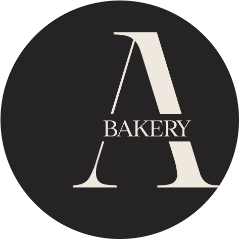 Logo for A Bakery with a large white letter A and the word BAKERY across the middle on a black circular background.