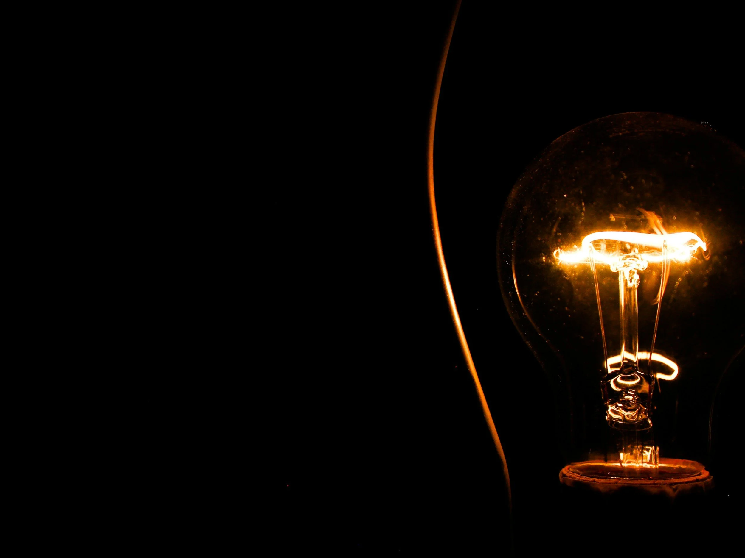 Close-up of an illuminated light bulb glowing in the dark.