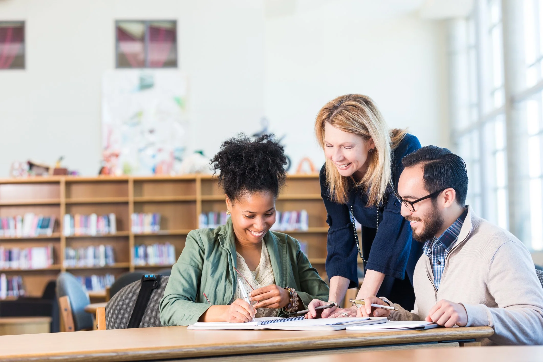 A group of young adults studying and collaborating together in a library.