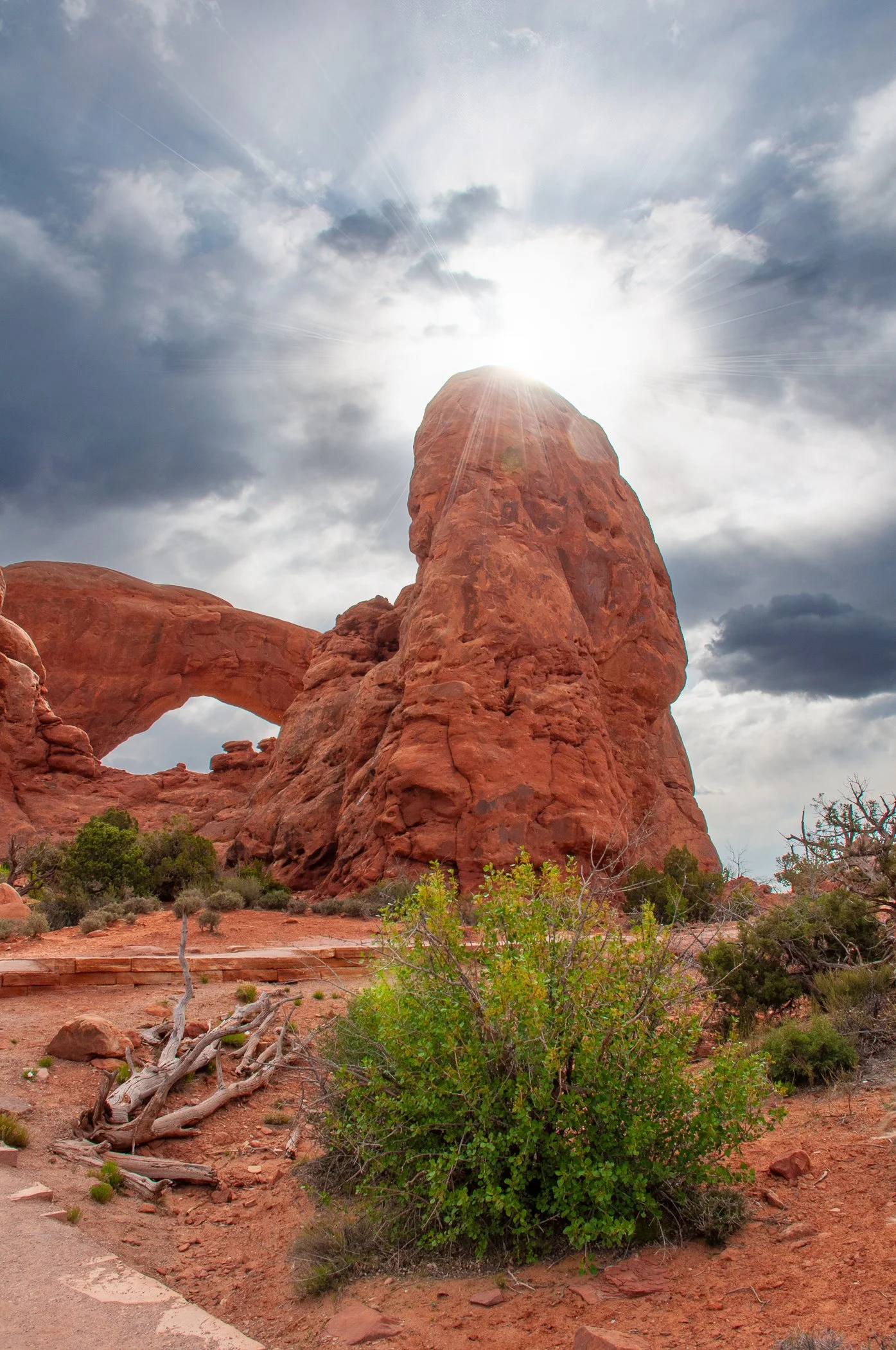 Sun peaking out from behind a rock formation.