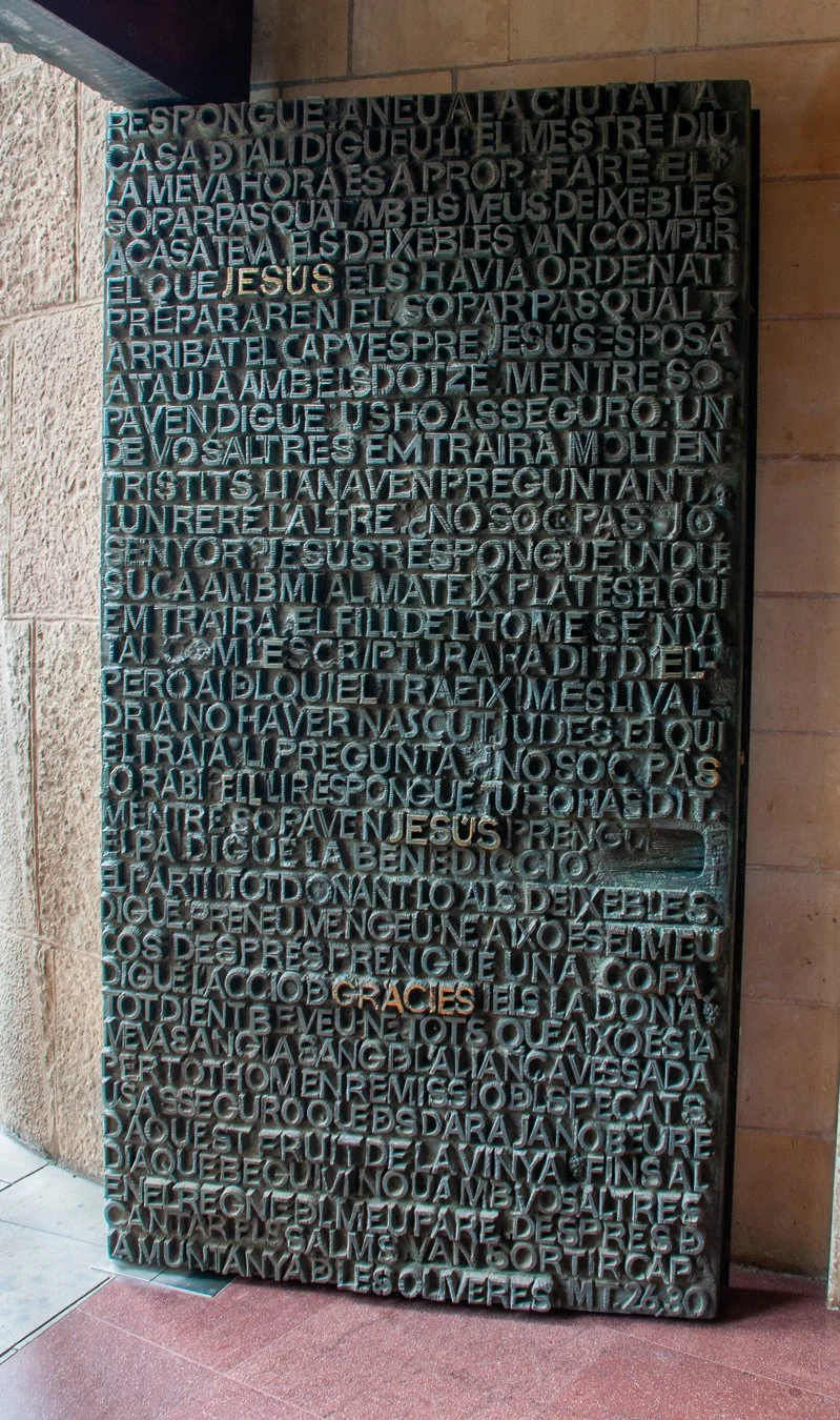 A black metal door with black and gold lettering covering it's surface.