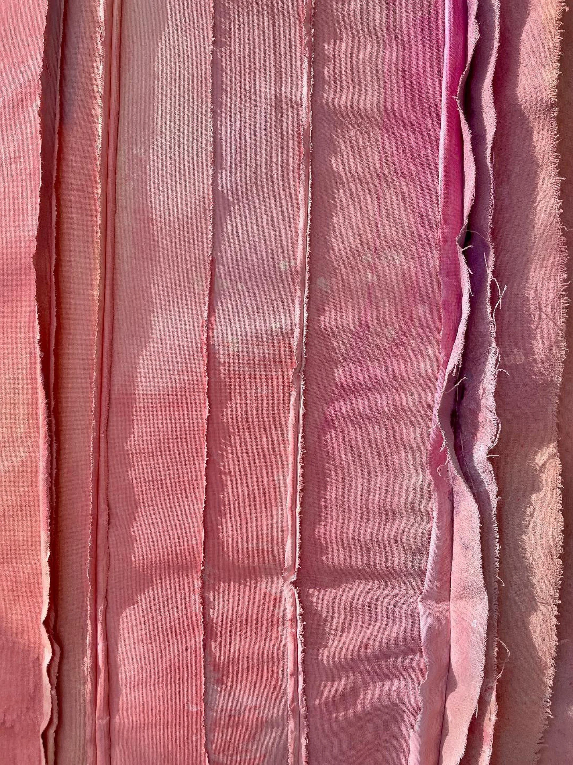 sunlit detail of canvas sewn together from salvaged canvas strips with fringed edges