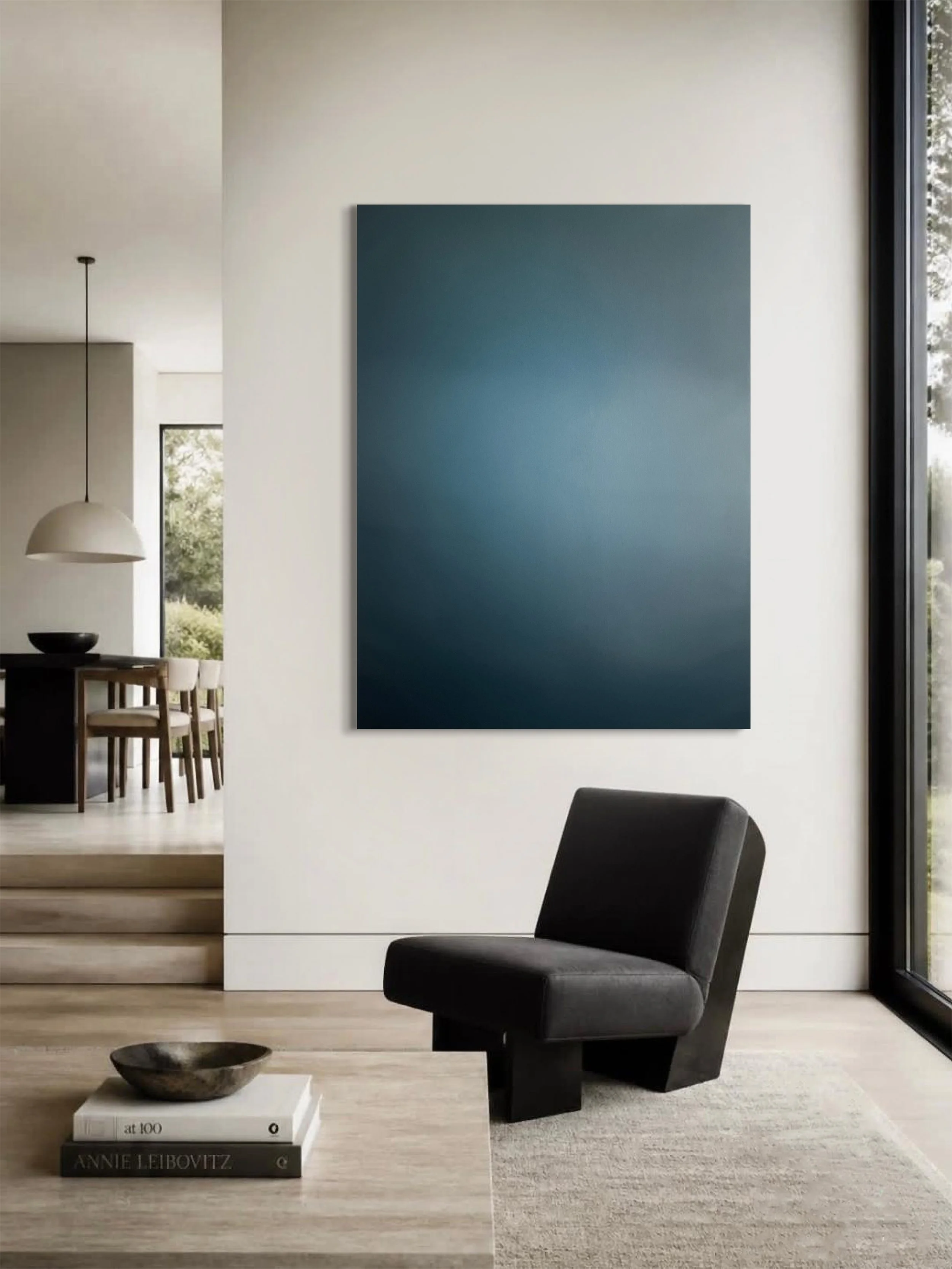 Steely blue color field painting with a lighter, luminous shade towards the center, hanging in a modern light filled living room textile 