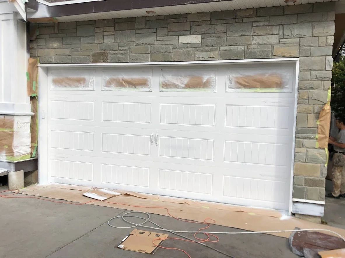 After! We've sprayed a coat of white on the garage door. We let it dry before removing the masking and doing touch ups!