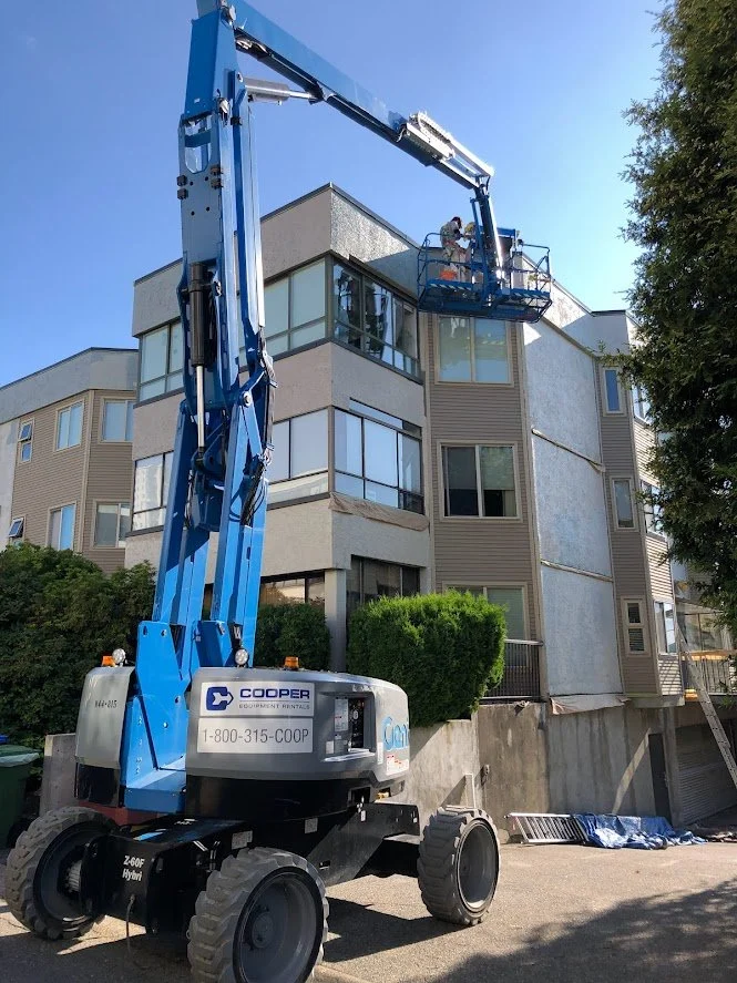 Using a boom lift to apply the primer and top coats!