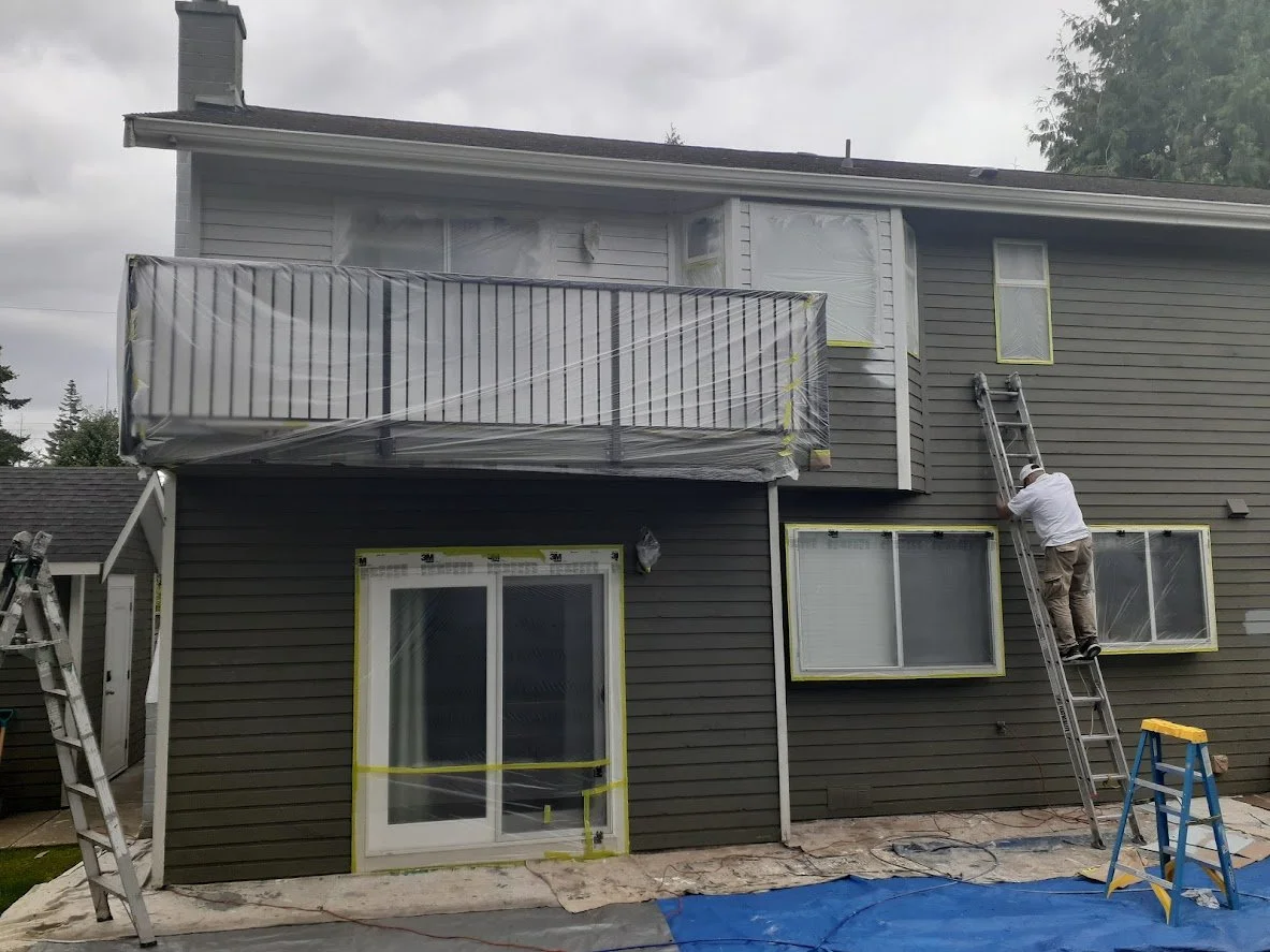 After prep, we had just sprayed the siding above the balcony! We are masking off the rest before spraying the rest of the siding. 