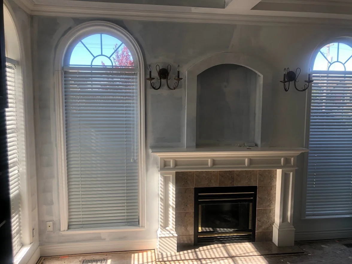 Before ... the client had just had this room renovated, and they had primed most of the walls (except behind that cabinet where you can see the unprimed area). They wanted the crown molding, the ceilings and the walls painted!